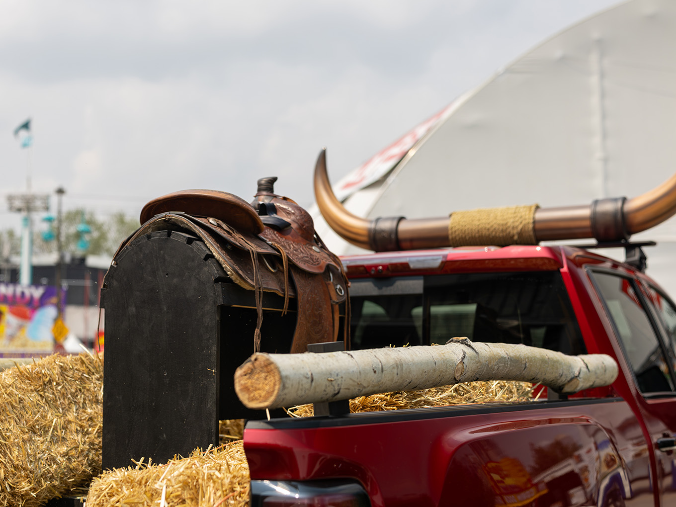 Detail of custom horn topper, saddle, and log rail styling on the GMC Stampede parade truck bed.