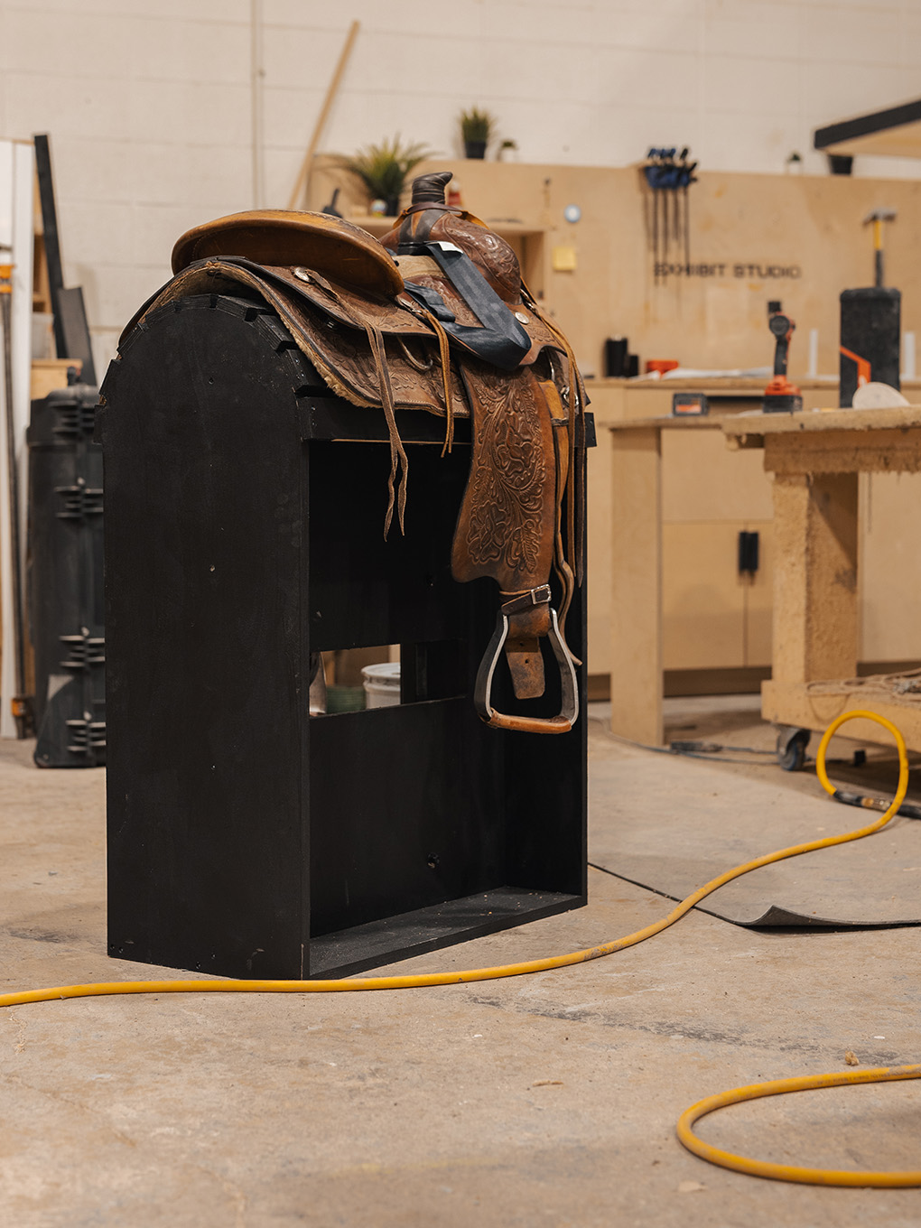 Vintage saddle mounted on a custom-built display stand at the Exhibit Studio fabrication shop.