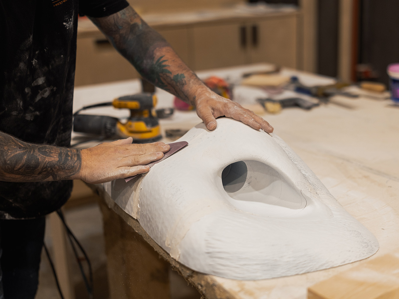 Exhibit Studio fabricator sanding a 3D-printed bull nose form for the custom GMC truck display.