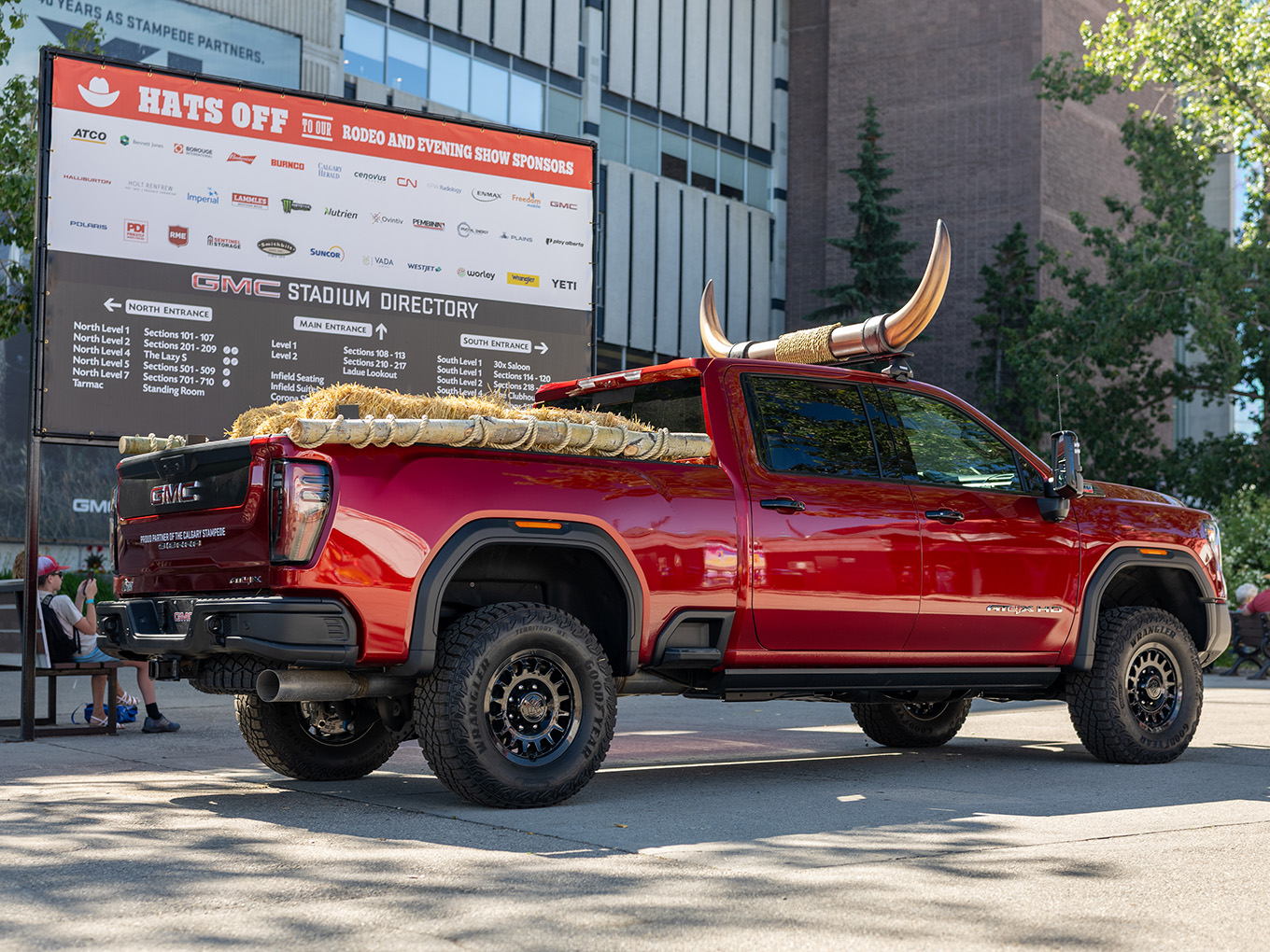 Side view of the custom GMC parade truck with fabricated horn topper and hay bale bed styling.