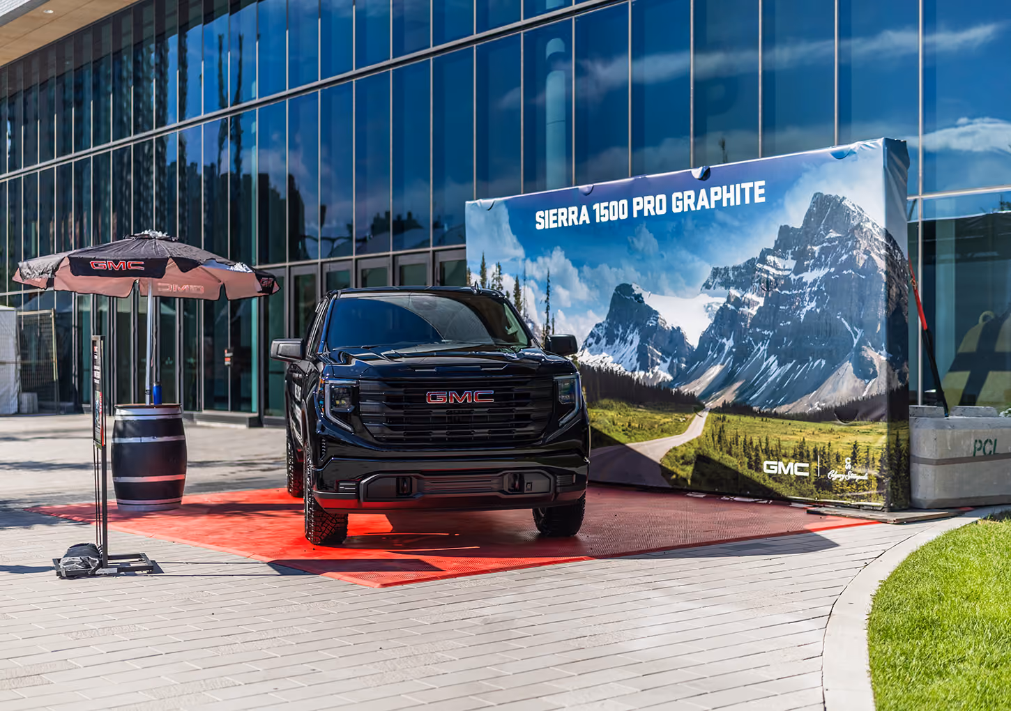 GMC Sierra 1500 satellite vehicle display with branded backdrop graphic outside the Calgary BMO Centre