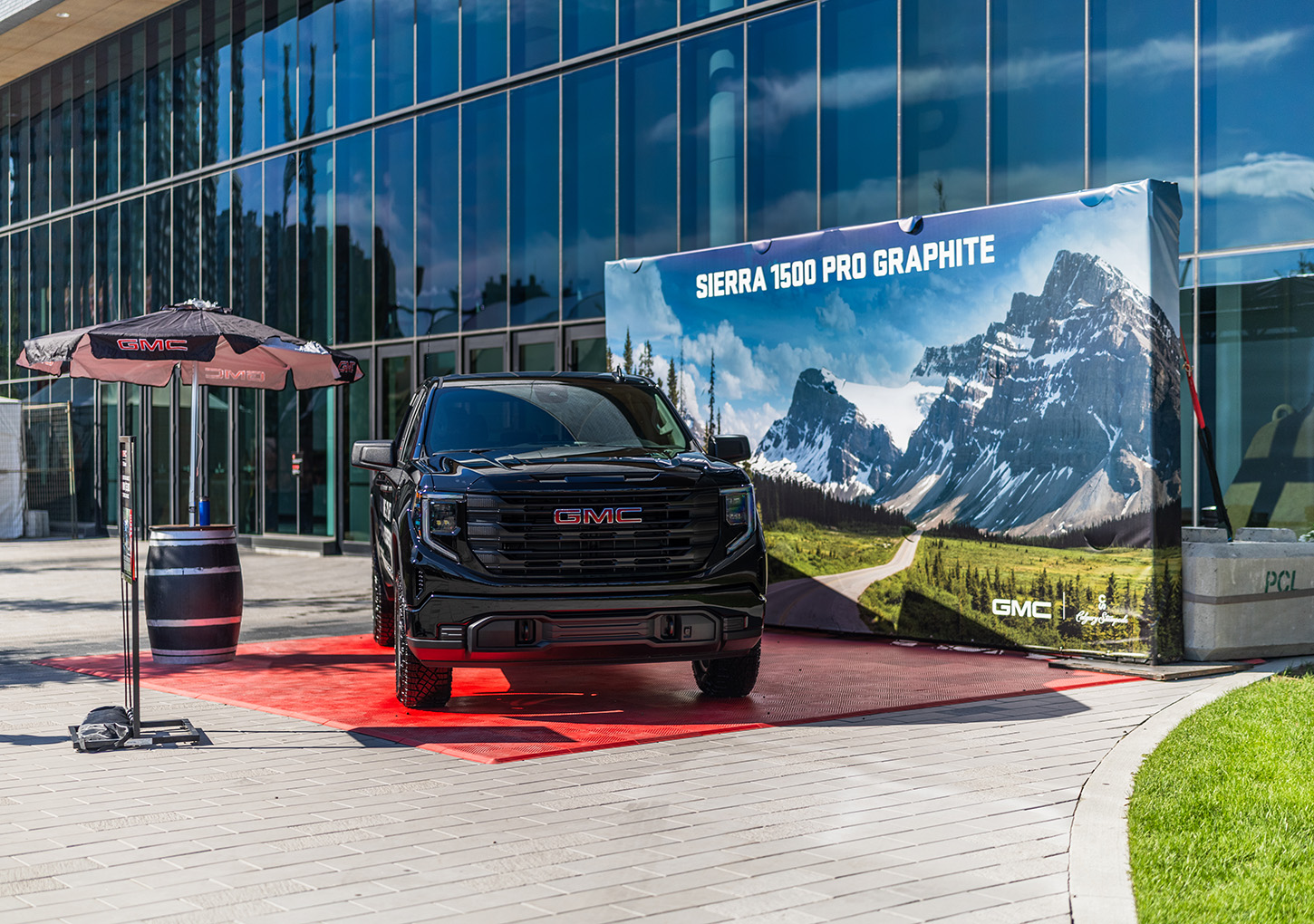 GMC Sierra 1500 satellite vehicle display with branded backdrop graphic outside the Calgary BMO Centre