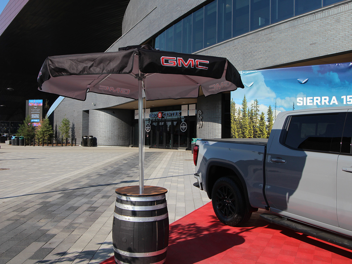 GMC satellite vehicle display with branded umbrella and barrel table outside the BMO Centre.
