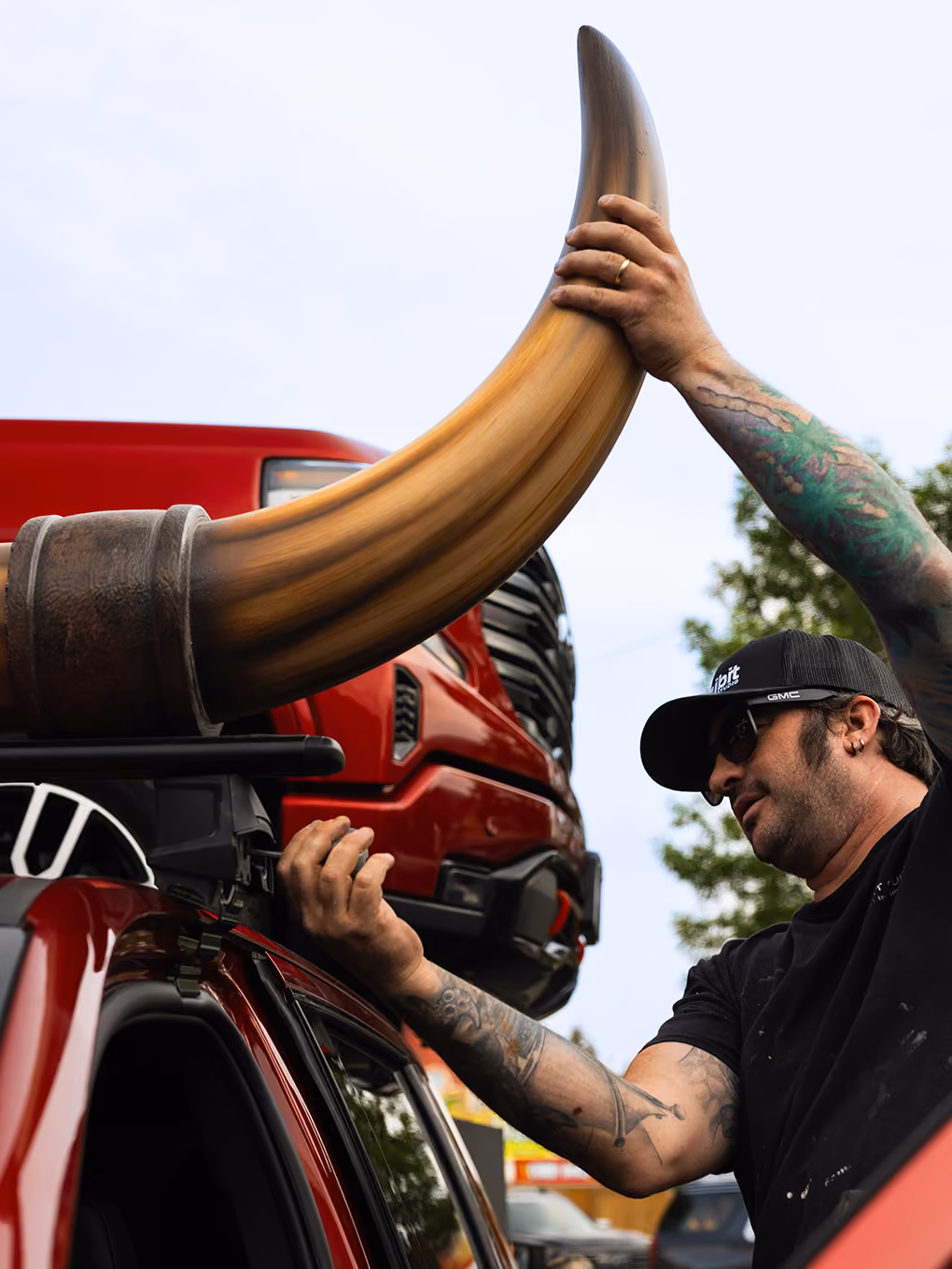 Exhibit Studio team member installing a fabricated bull horn onto the roof rack of a GMC parade truck.