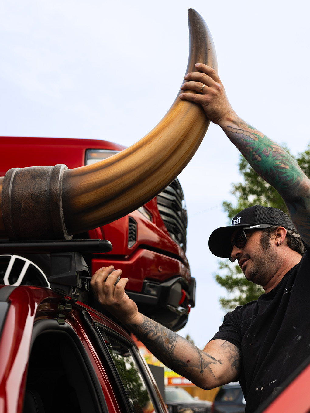 Exhibit Studio team member installing a fabricated bull horn onto the roof rack of a GMC parade truck.