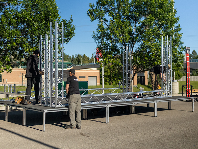 Exhibit Studio crew assembling custom truss staging for a GMC Stampede event.