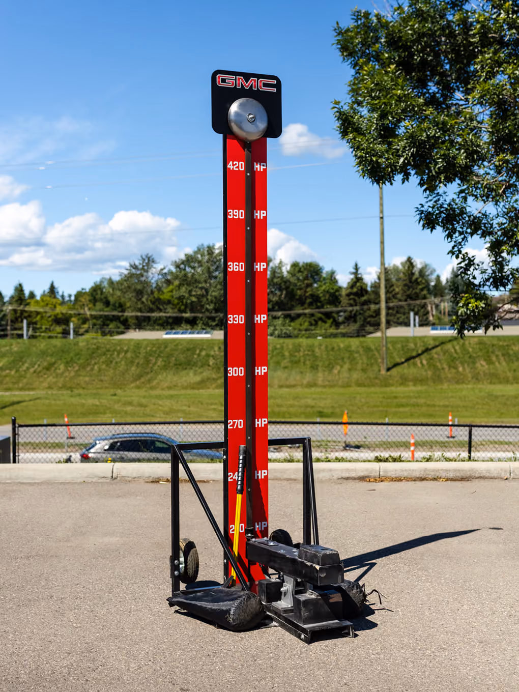 Custom GMC-branded high striker strength game staged outdoors for a Calgary Stampede event.