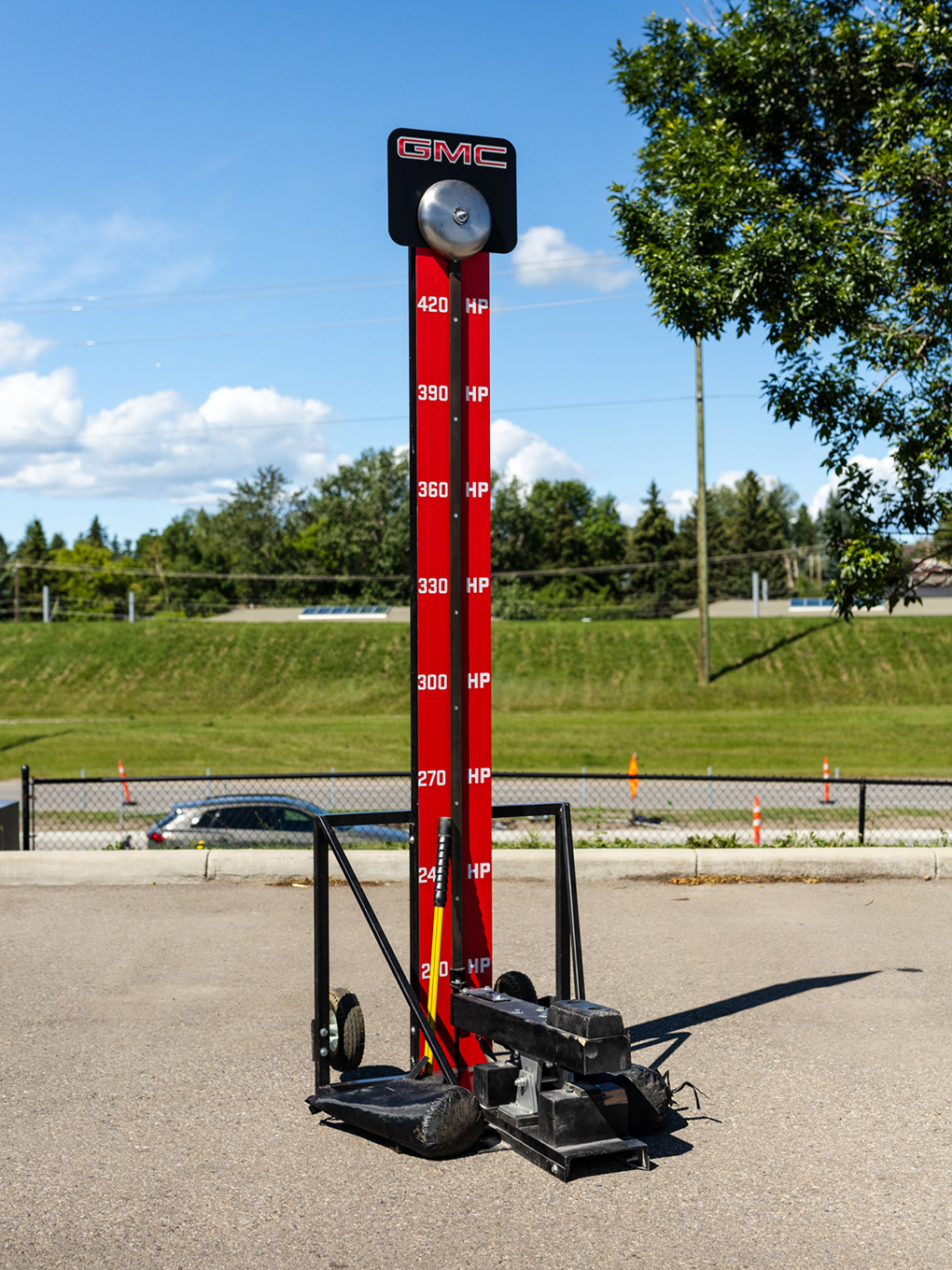 Custom GMC-branded high striker strength game staged outdoors for a Calgary Stampede event.