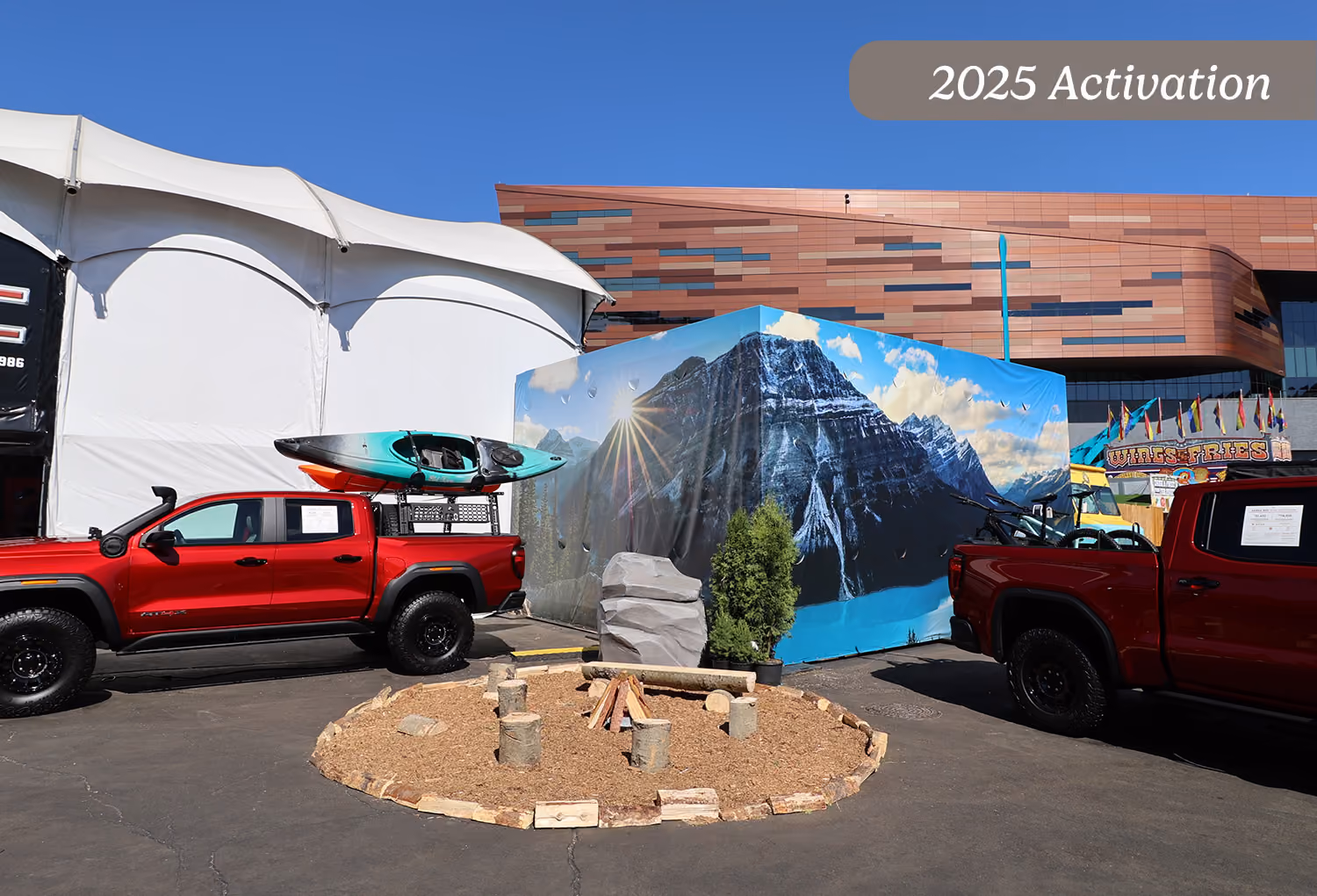 2025 campfire zone display with mountain graphic backdrop staged beside the midway tent.