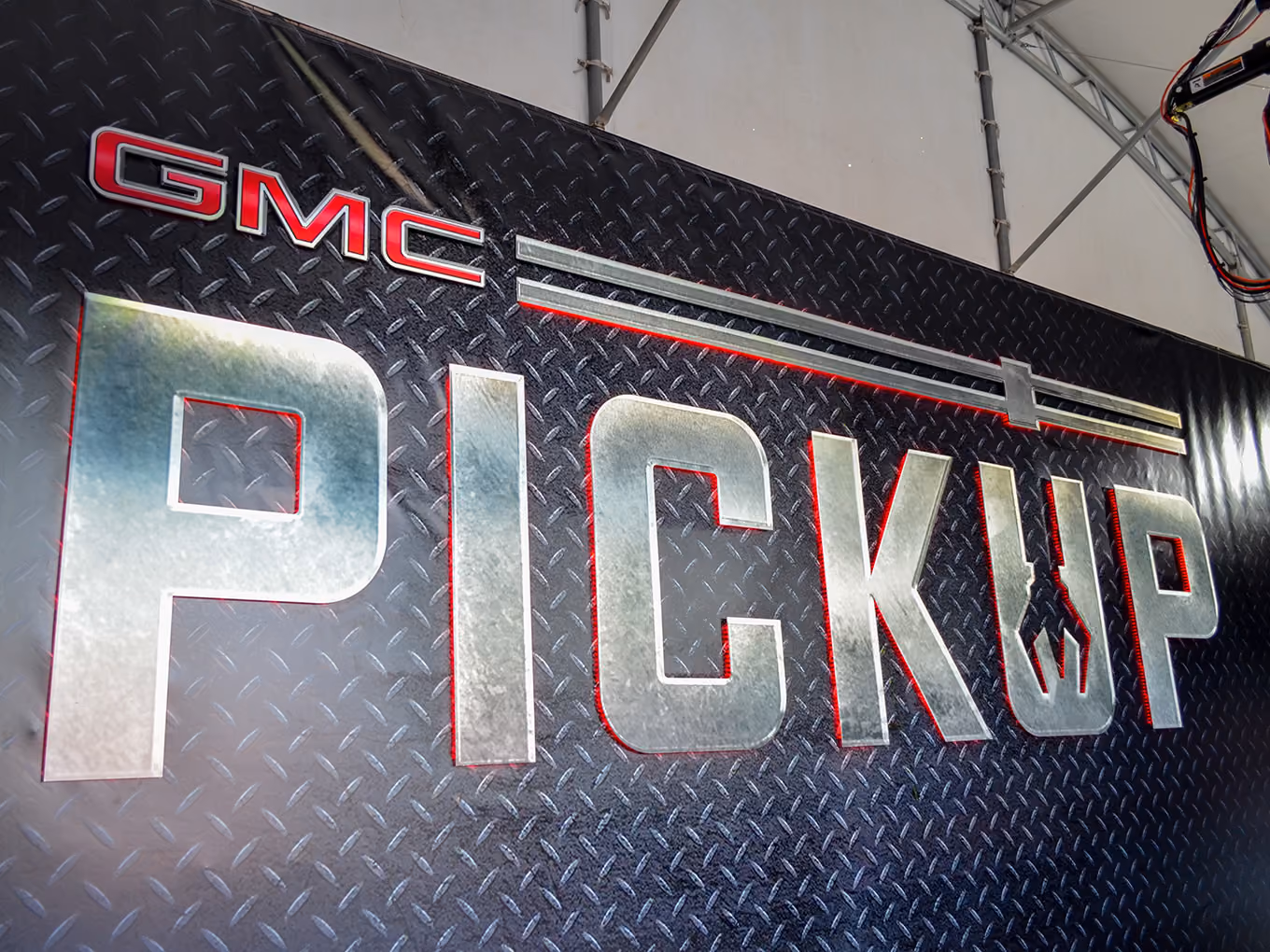 Custom illuminated GMC "Pickup" signage with diamond-plate texture and LED edge lighting.