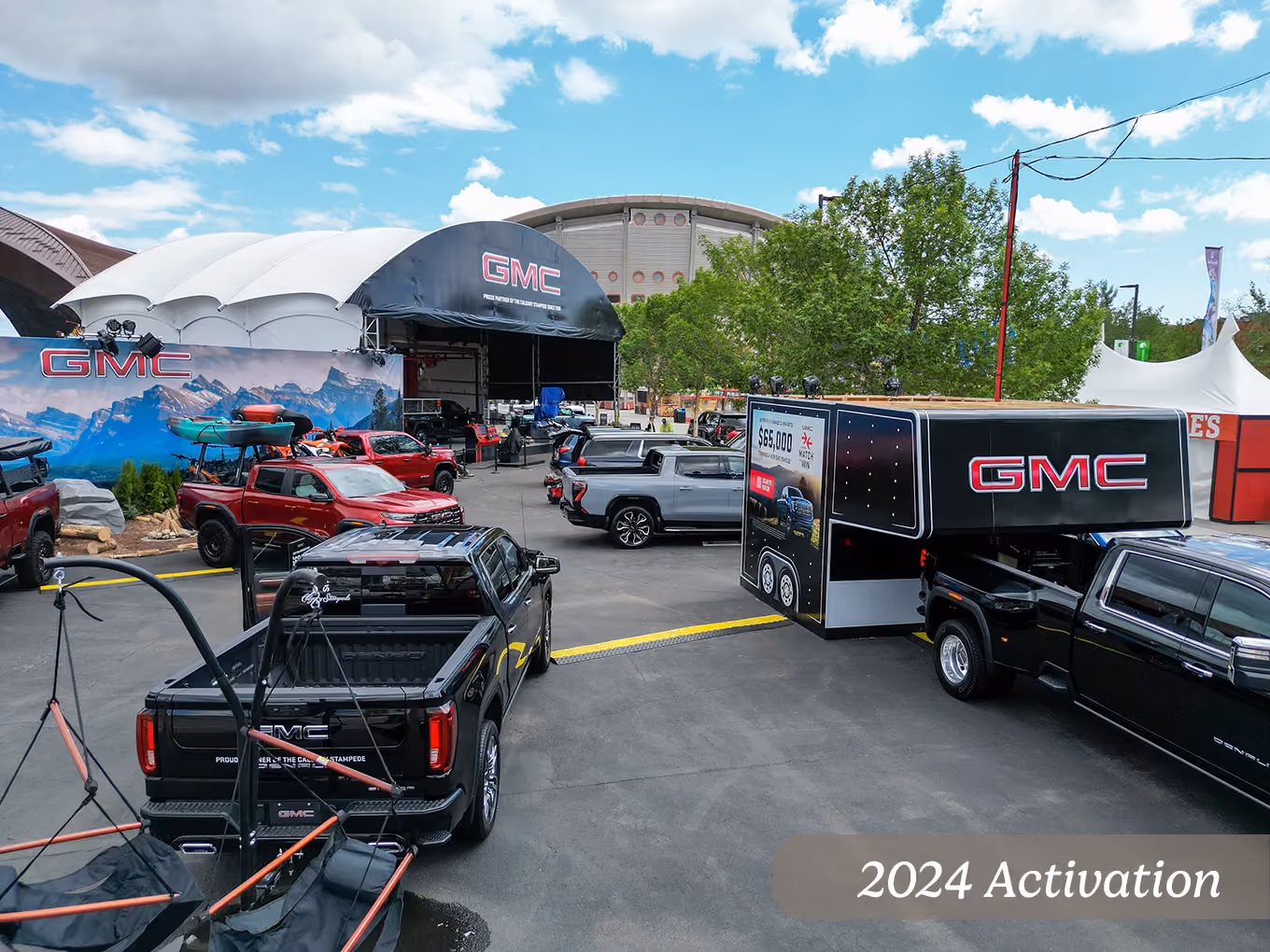 2024 aerial view of the GMC midway activation with contest trailer, display trucks, and campfire zone.