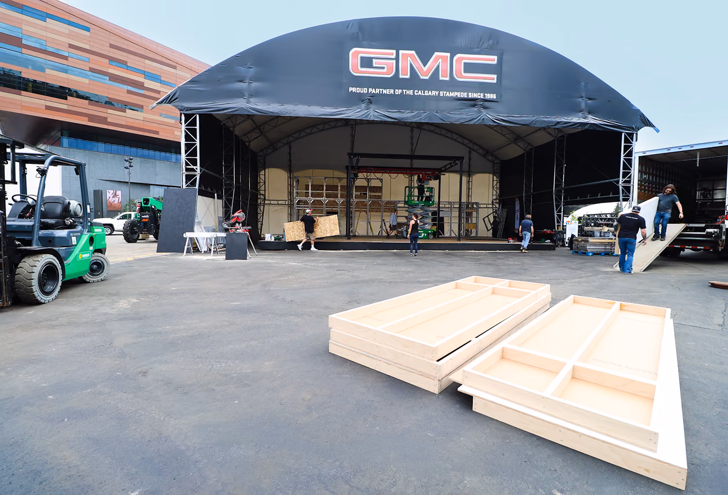 Exhibit Studio crew installing the branded GMC midway tent structure and stage flooring.