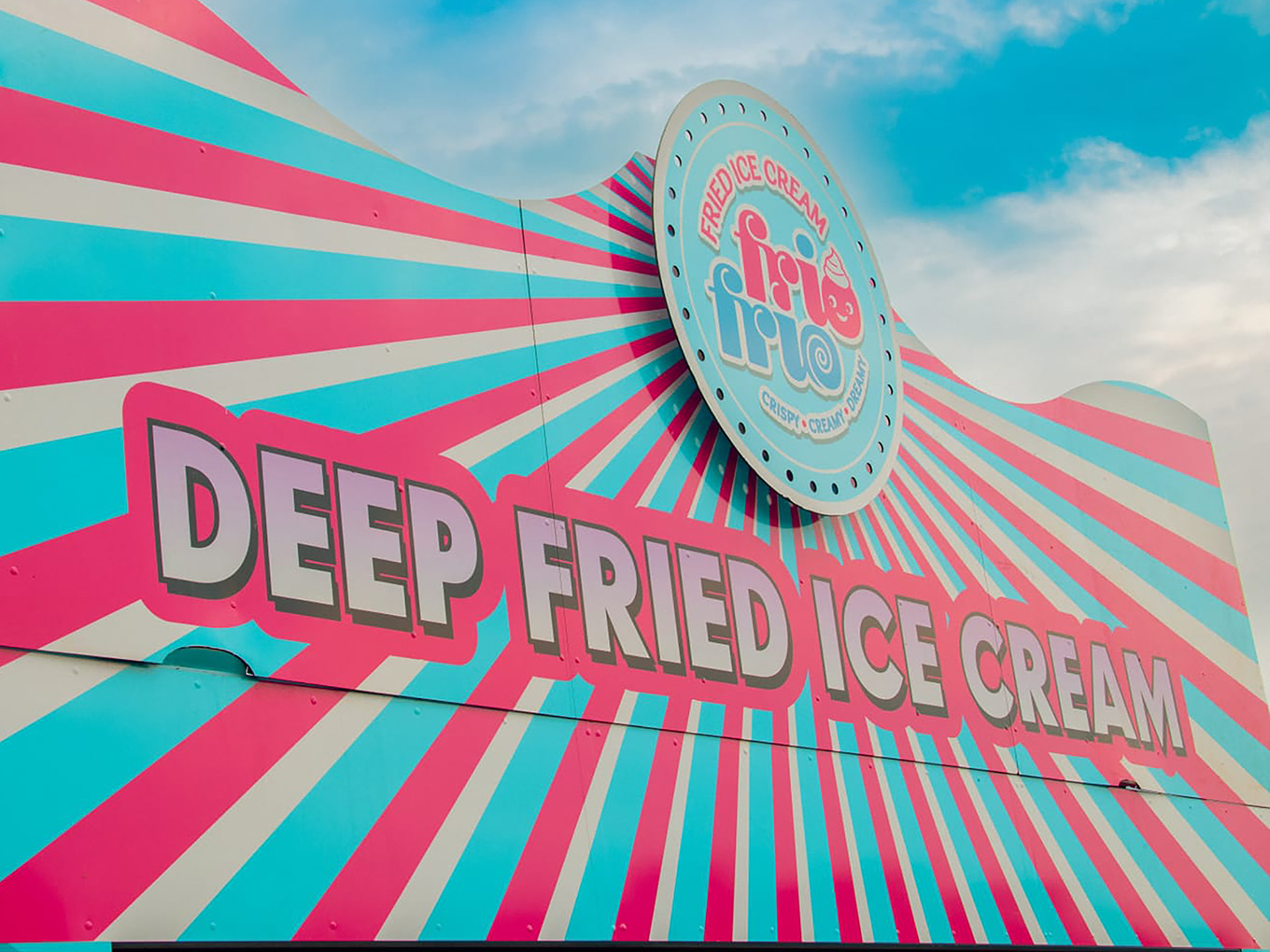 Close-up of the Frio Frio logo and "Deep Fried Ice Cream" header, with pink and blue sunburst stripes against the sky.