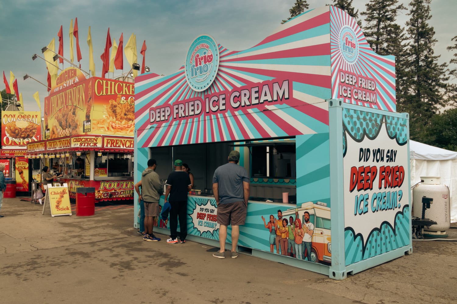 The Frio Frio stand at a fair, with a side panel that asks "Did you say deep fried ice cream?" as customers gather at the counter.