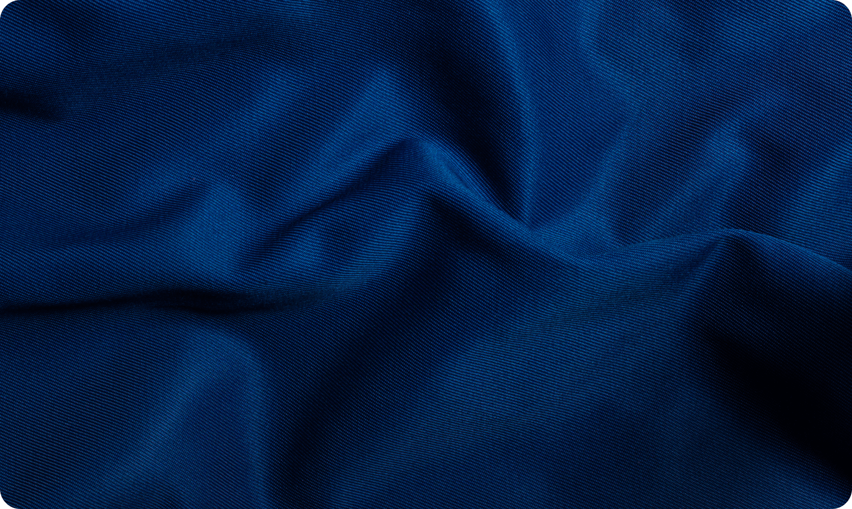 Close-up of dark blue fabric with fine ribbed texture and soft folds.