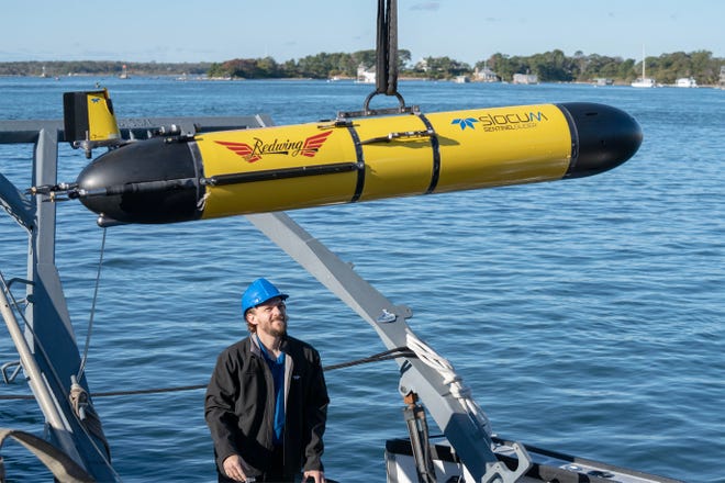 Teledyne's Garrett Miller guides the Redwing glider to the dock for a kick off ceremony of the round the world Sentinel Mission at the Woods Hole Oceanographic Docks. Photo taken on Oct. 10, 2025