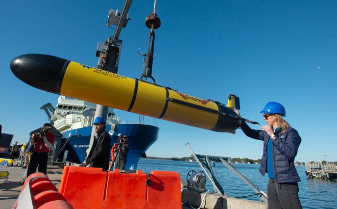 Teledyne glider support manager Cordie Goodrich guides the underwater glider Redwing to a display stand at the Woods Hole Oceanographic Docks for the kick off ceremony of the Sentinel Mission. The Mission will send the glider on an around the world trip stopping at 7 different ports. The voyage will take 1,553 days, total travel distance 63,463 kilometers. Photo taken on Oct. 10, 2025