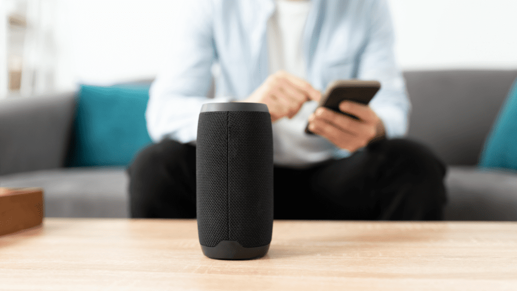 man with mobile phone and smart speaker