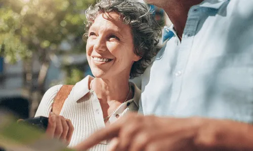 a couple looking forward and pointing at a map