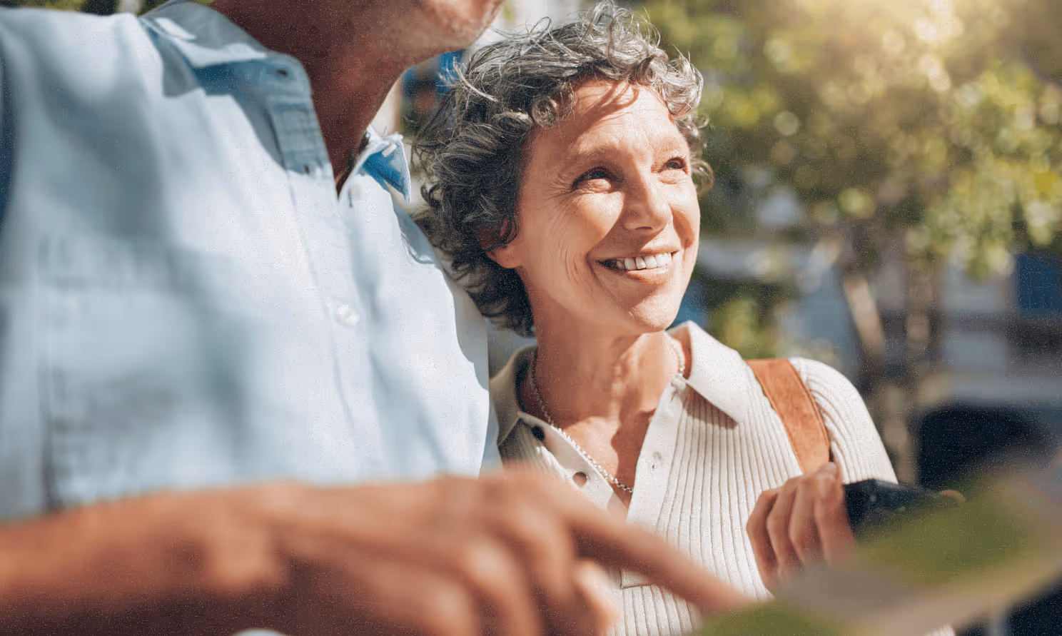 A man standing next to a woman holding a map and looking forward.