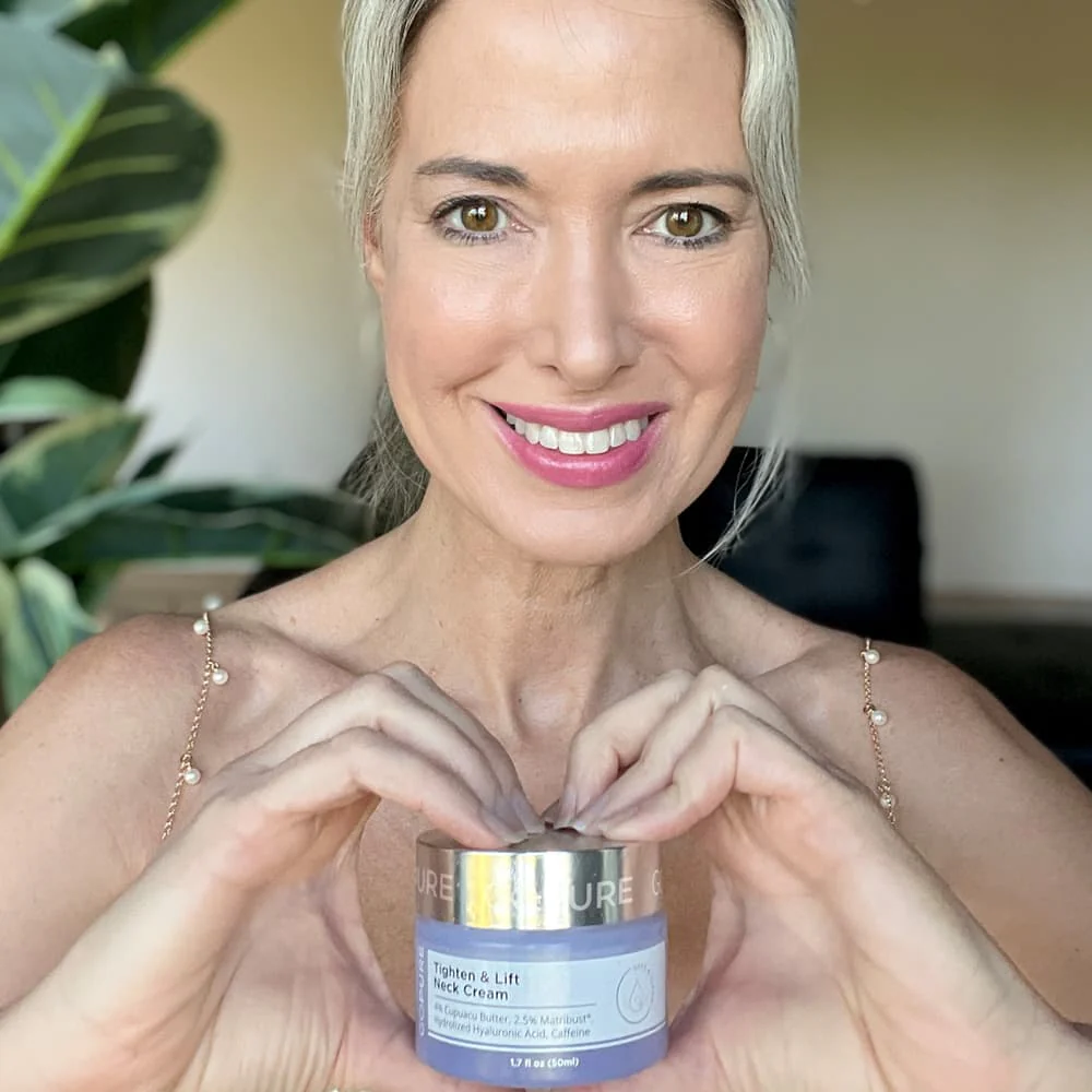 Mujer sonriente sosteniendo la crema GoPure