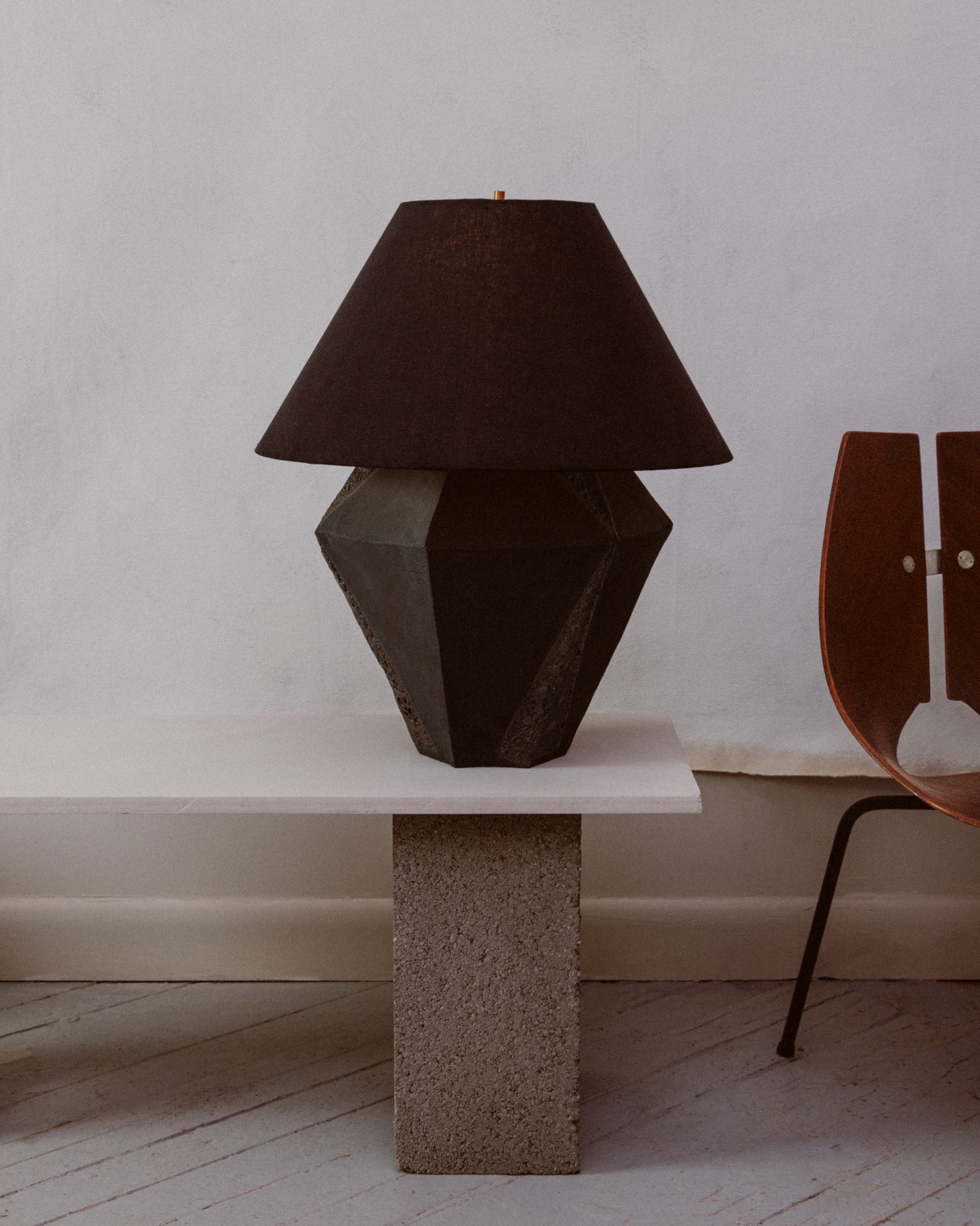 Staged photo of a table lamp and part of a chair