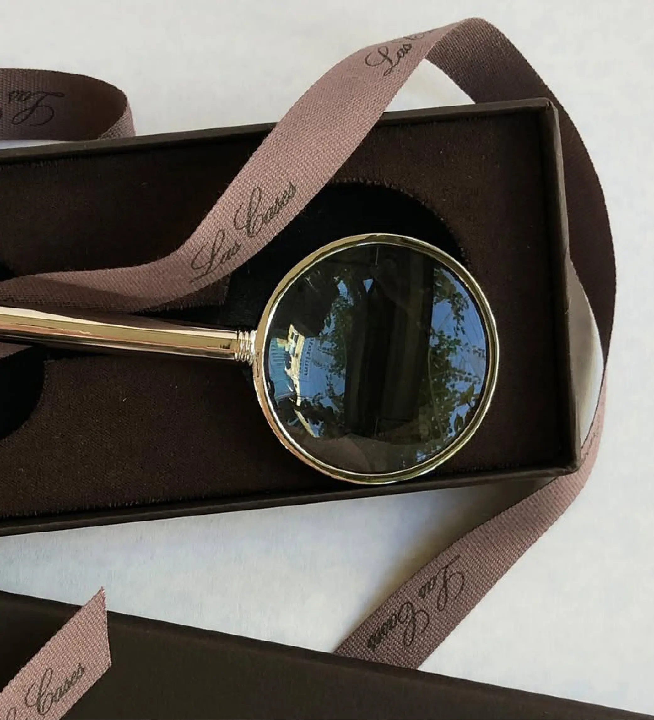 Boîte sur mesure avec calage velours accueillant une loupe dorée