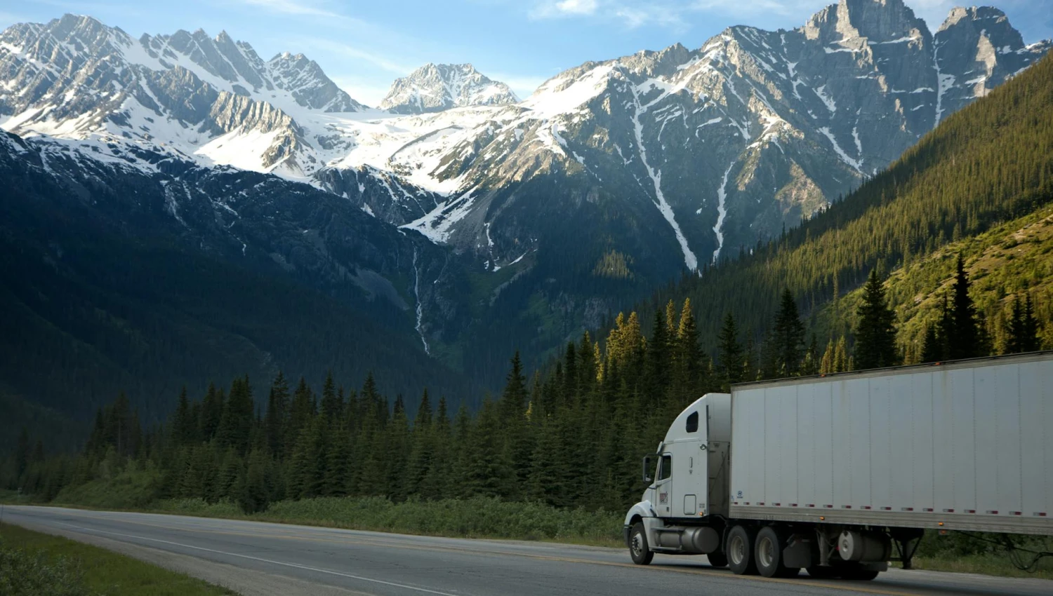 A truck driving on a highway near the mountains