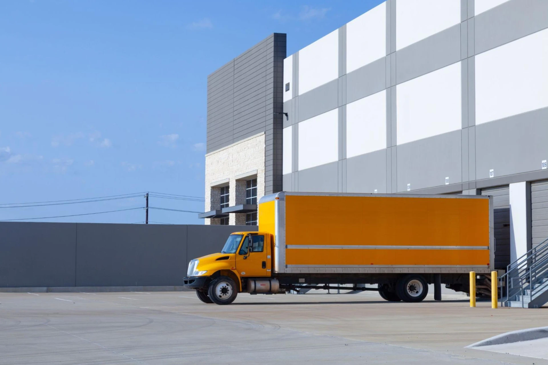 An orange truck backing into a dock