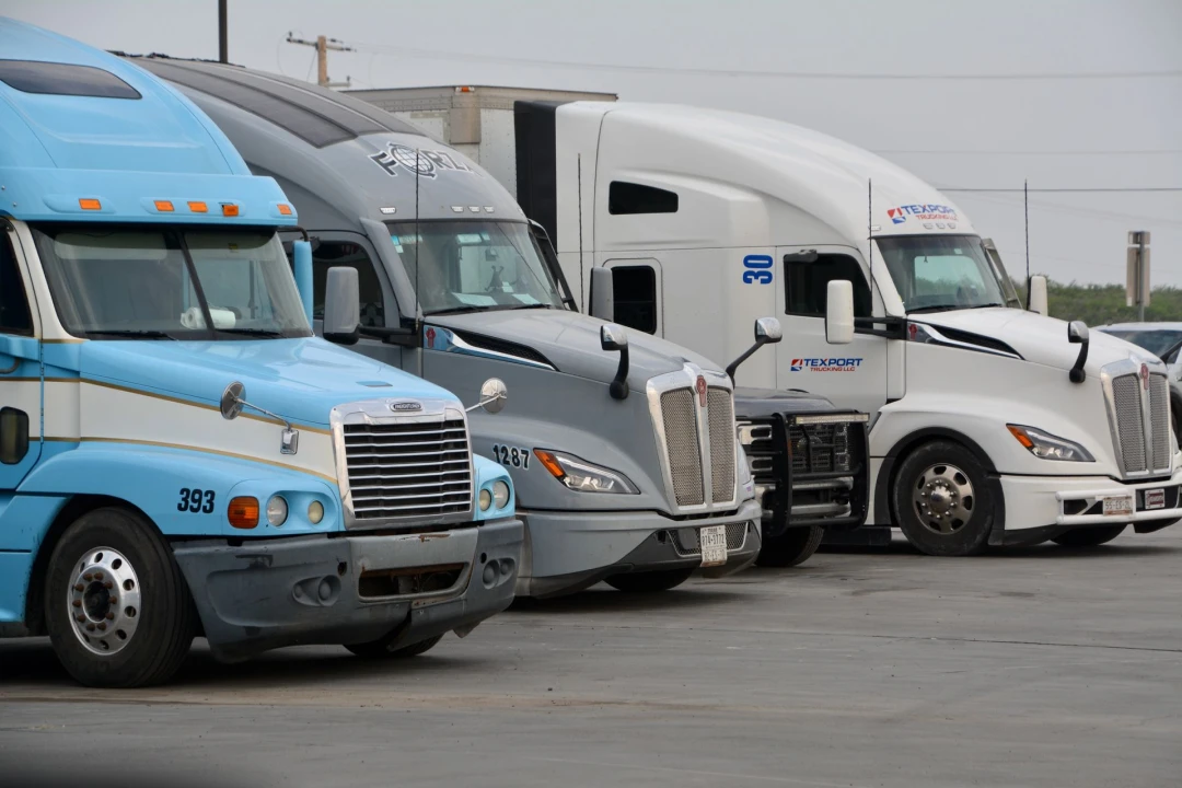 A row of parked semi trucks, showcasing various models and colors