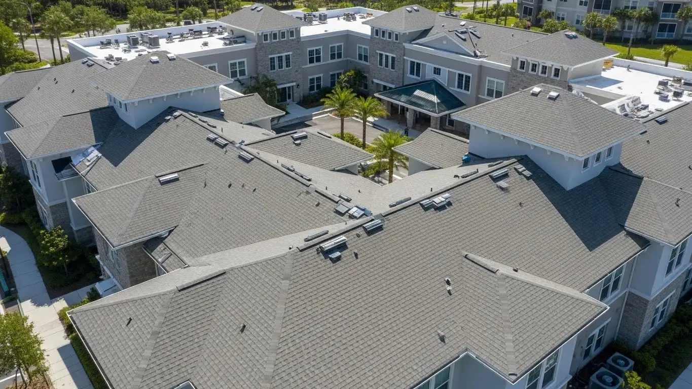 Completed commercial roofing project with new shingle installation on a multifamily building, no people or equipment