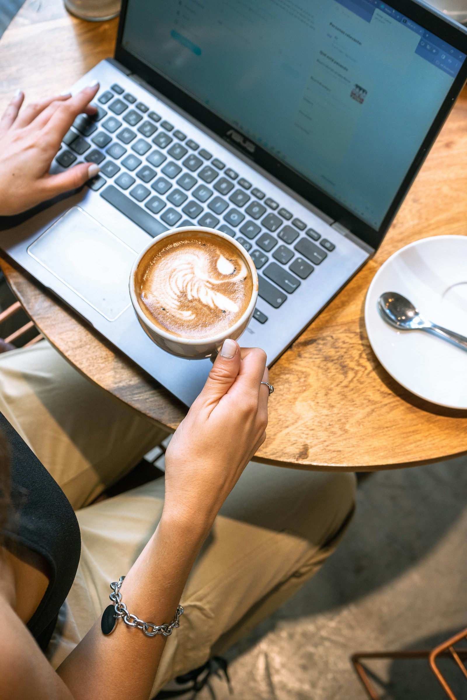 Laptop och kaffe på ett bord, sett ovanifrån