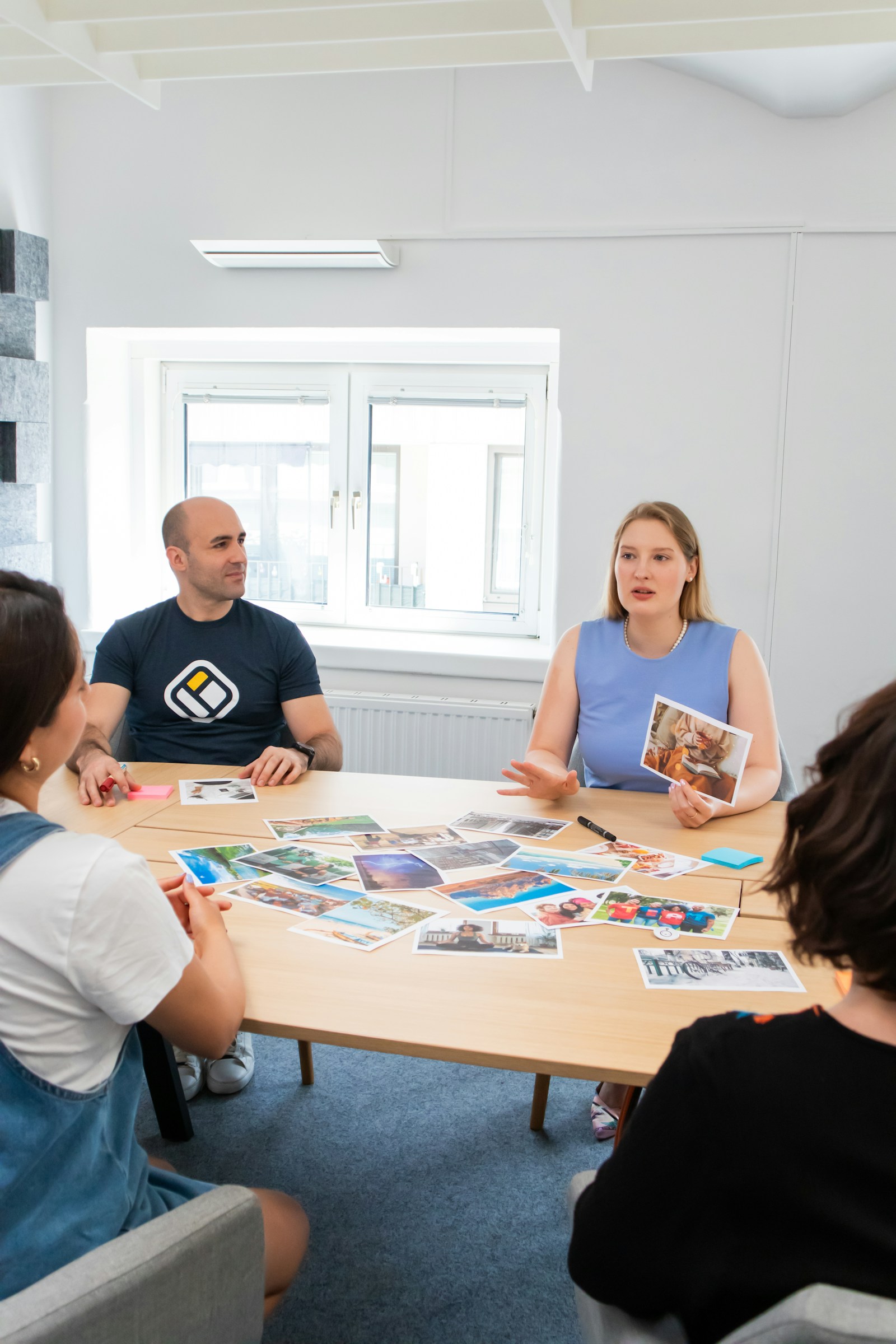 Personer runt ett runt bord i ett ljust mötesrum
