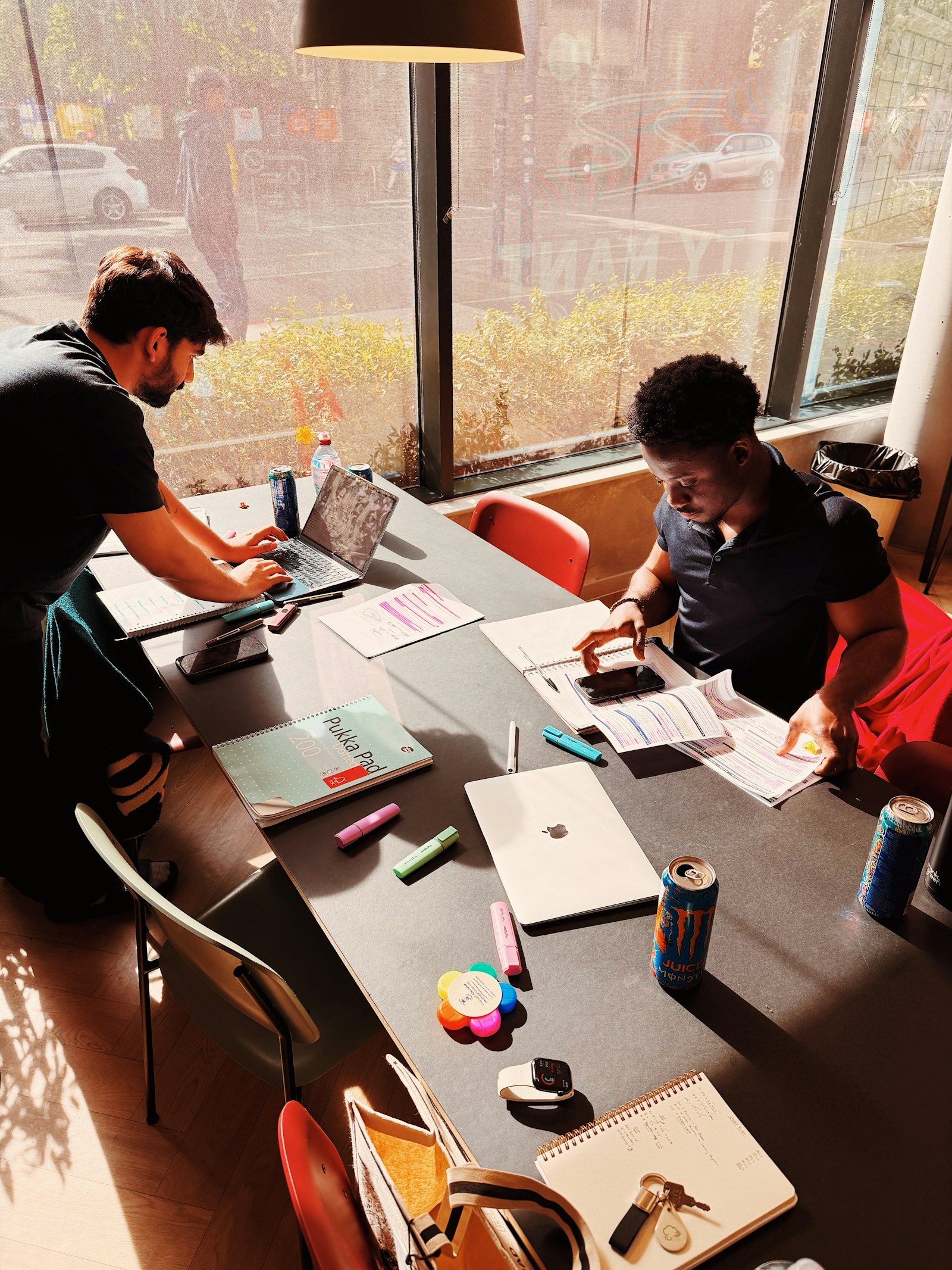 Team arbetar vid ett stort bord med laptops, sett ovanifrån