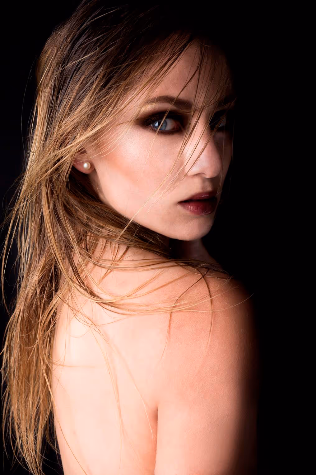 Modelo con fondo negro de lado mirando hacía la cámara
