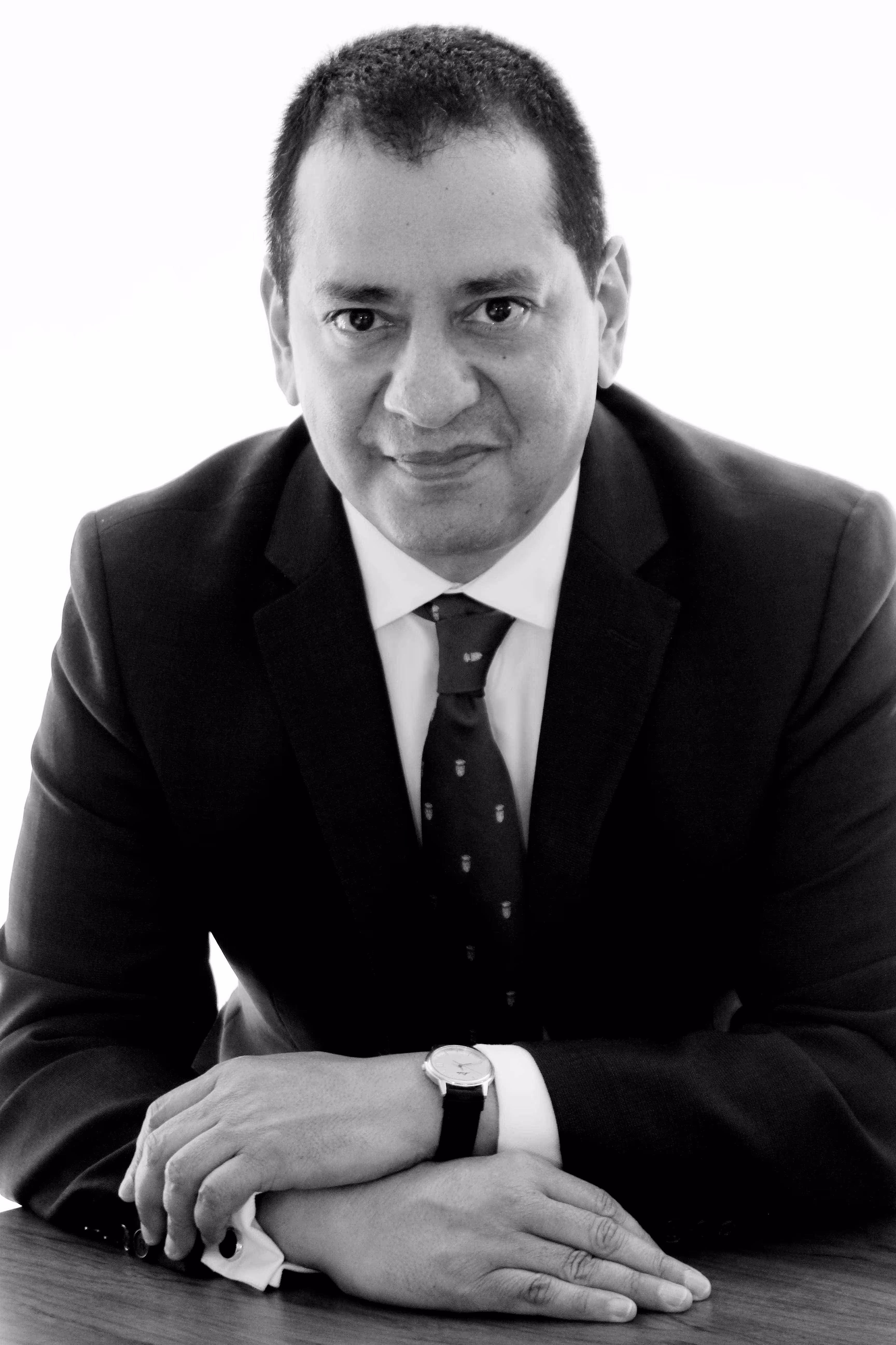 Fotografía blanco y negro de retrato de hombre con mirada fija a la cámara.