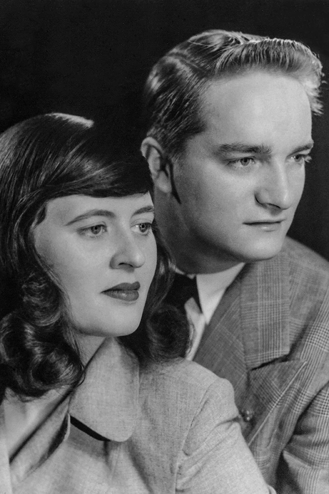 Black and white portrait of a woman with curled hair and a man with neatly combed hair looking to the right.