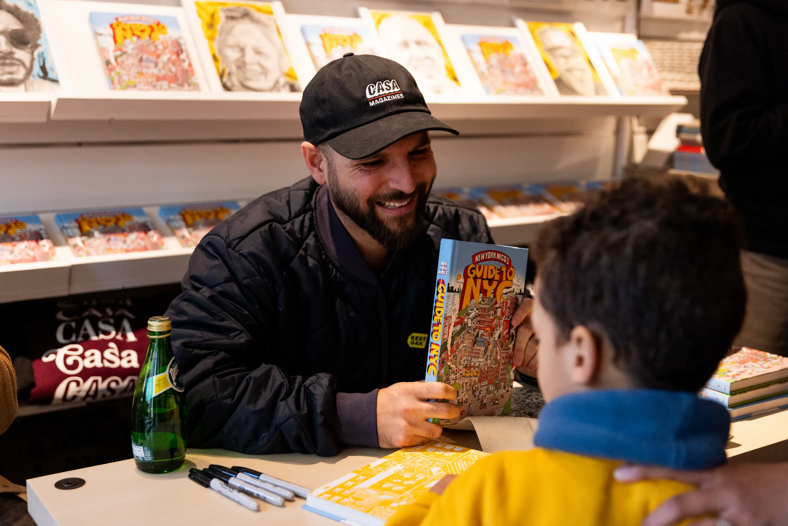 Candid portrait of New York Nico smiling with fan inside Casa Magazines — So & So Productions street culture photography.