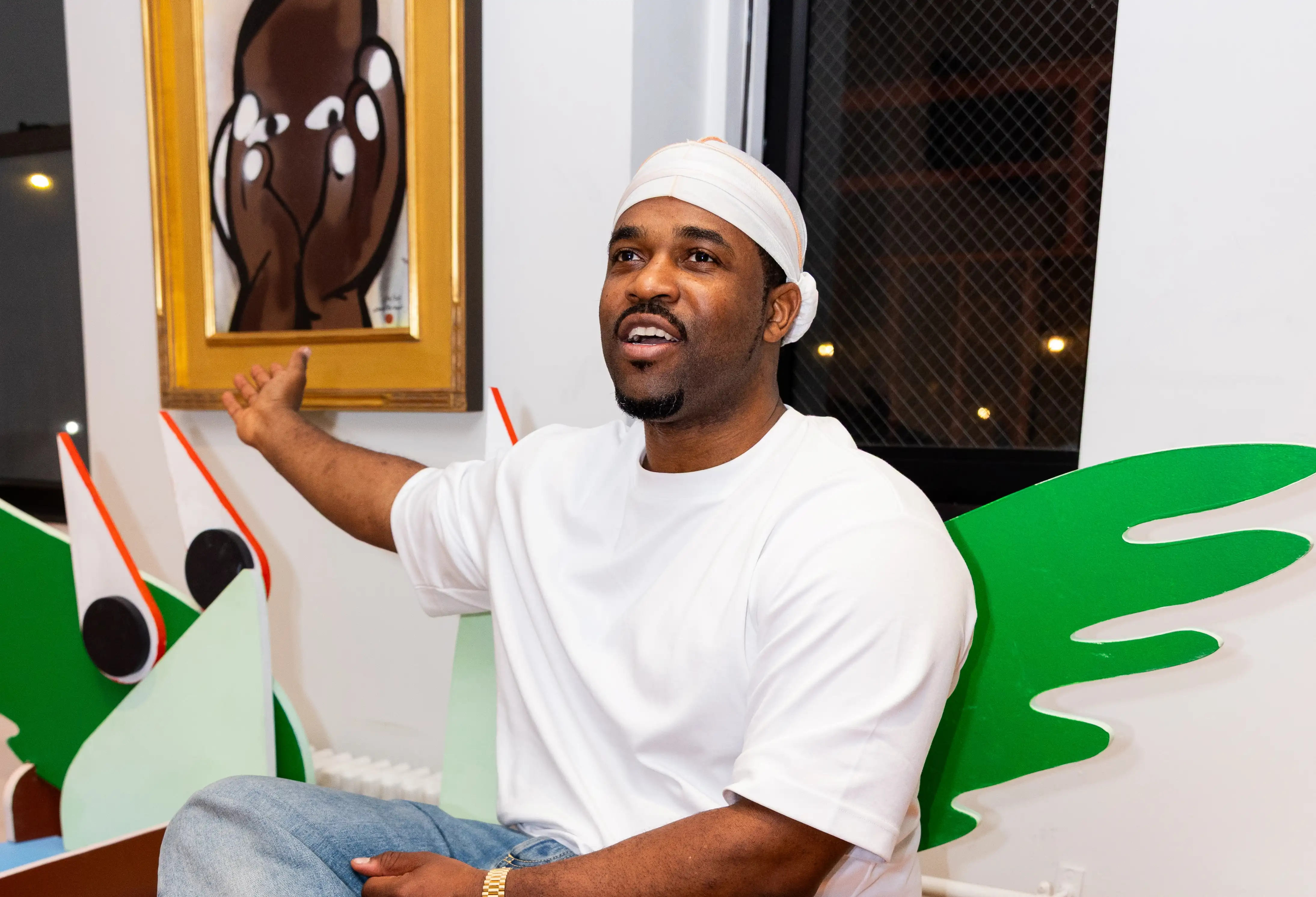 A$AP Ferg posing near frame of “French Tips” painting at CHOSEN Exhibition — So & So Productions image