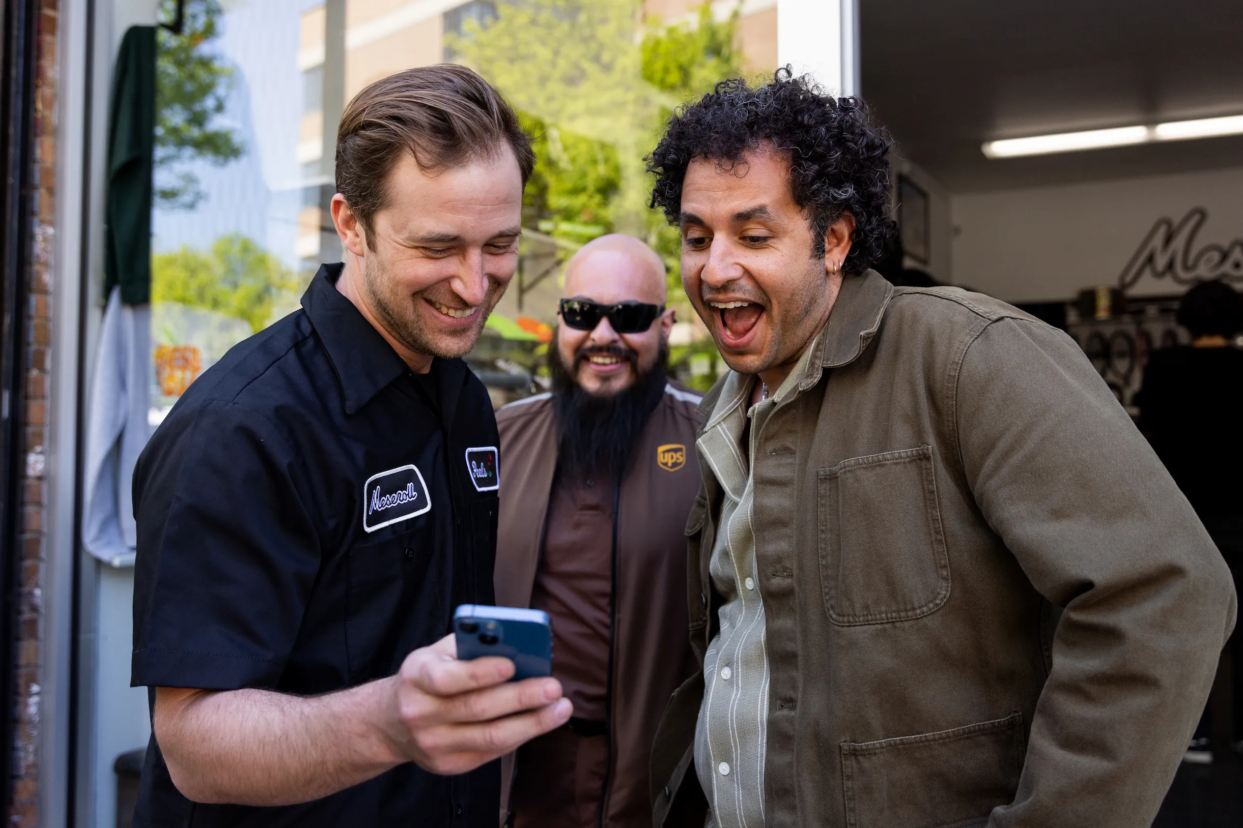 Portrait of Kareem Rahma laughing with small-business owner alongside UPS driver stop — So & So Productions candid photo