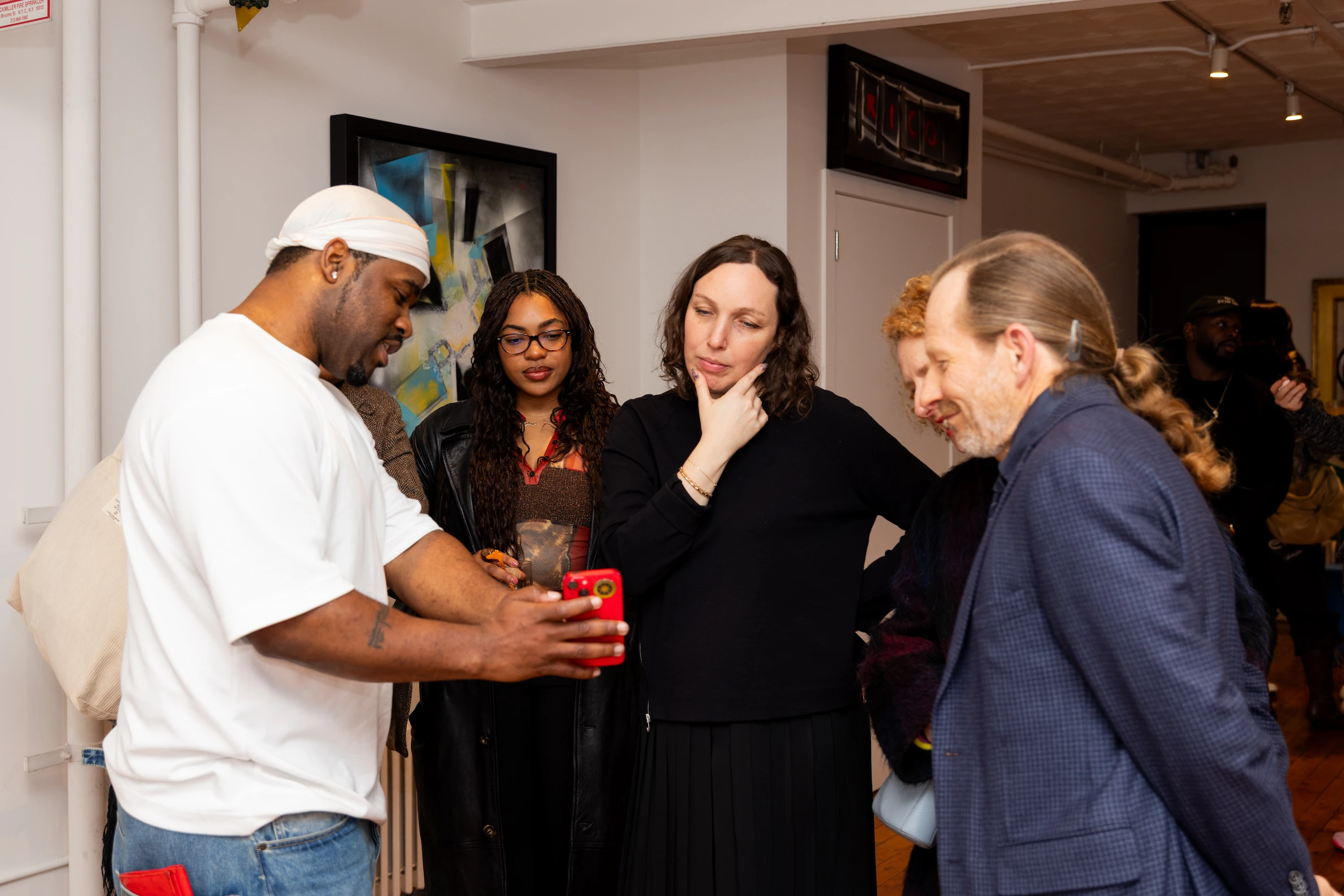 Candid photo of guests viewing A$AP Ferg’s artwork during the CHOSEN Exhibition opening — So & So Productions documentary photo