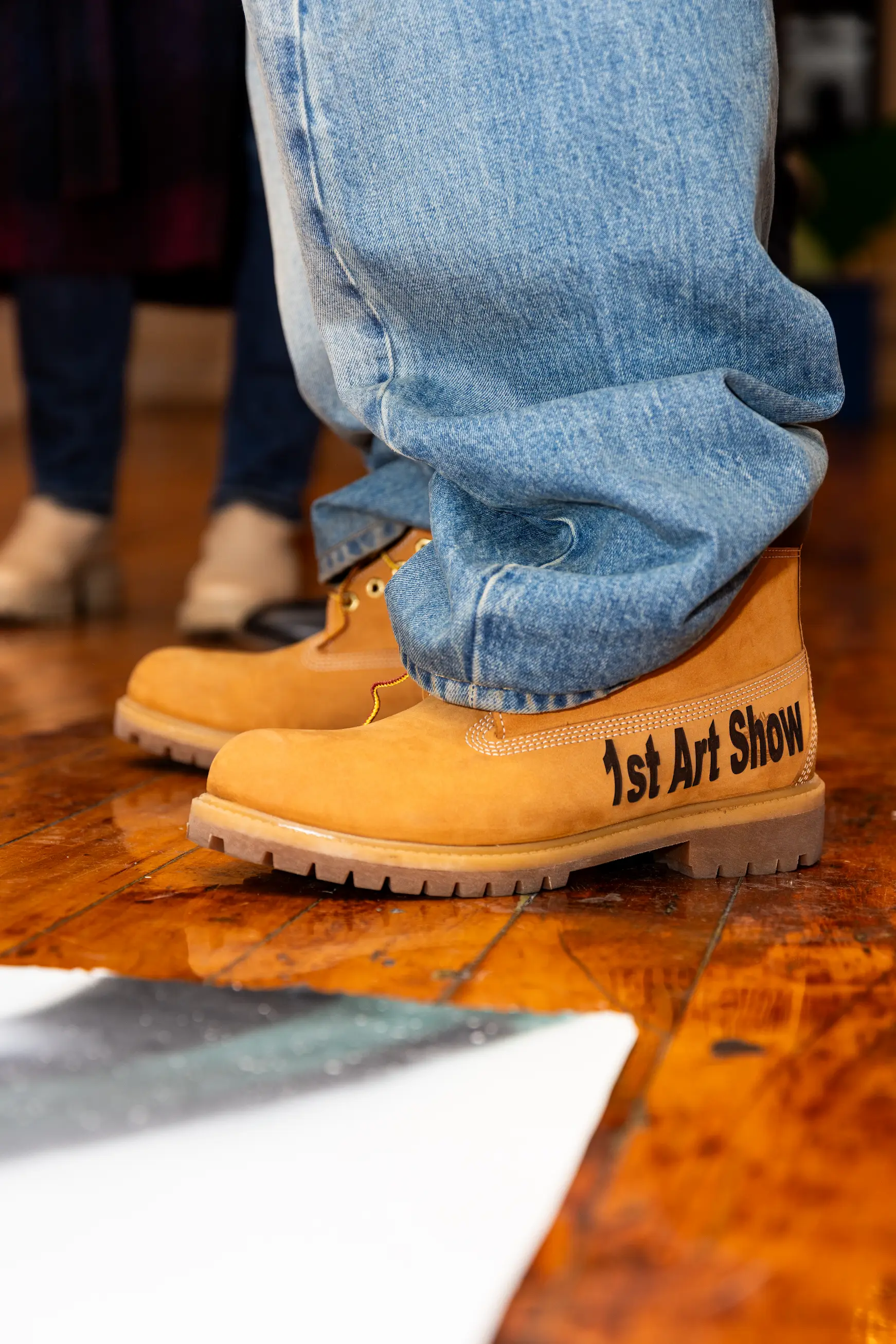 Close-up of A$AP Ferg’s customized Timberland boots inscribed “1st Art Show” at CHOSEN Exhibition — So & So Productions creative detail photo.