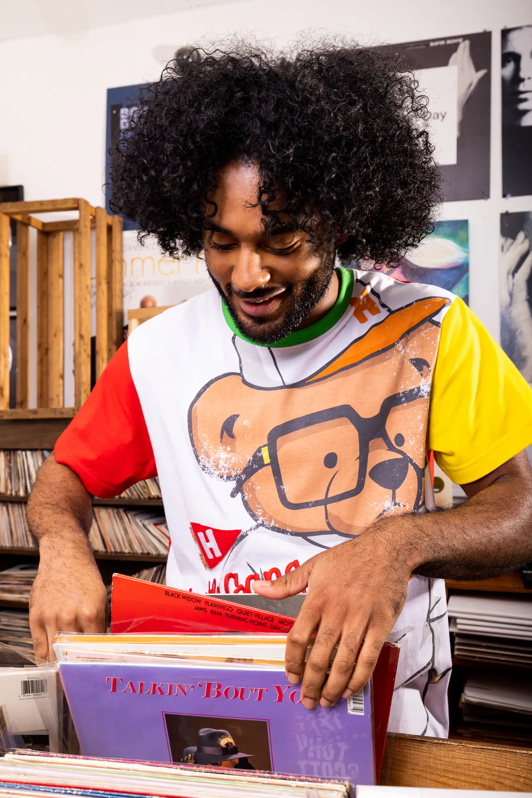 Model browsing vinyl records at Birdland Music in Virginia Beach wearing AKOO polo — So & So Productions fashion photo.