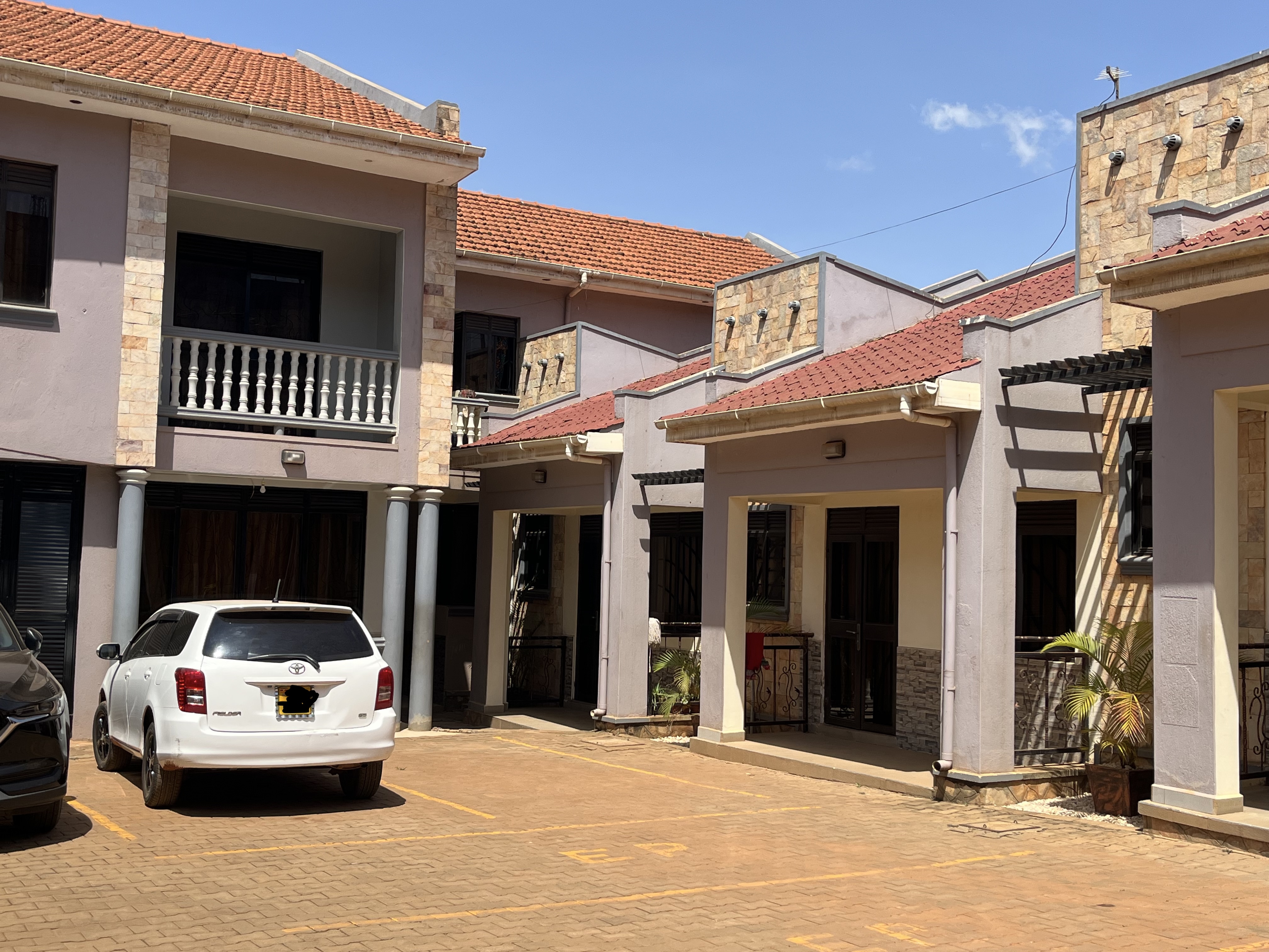 Rental apartment compound with paved parking and landscaped surroundings in Namugongo