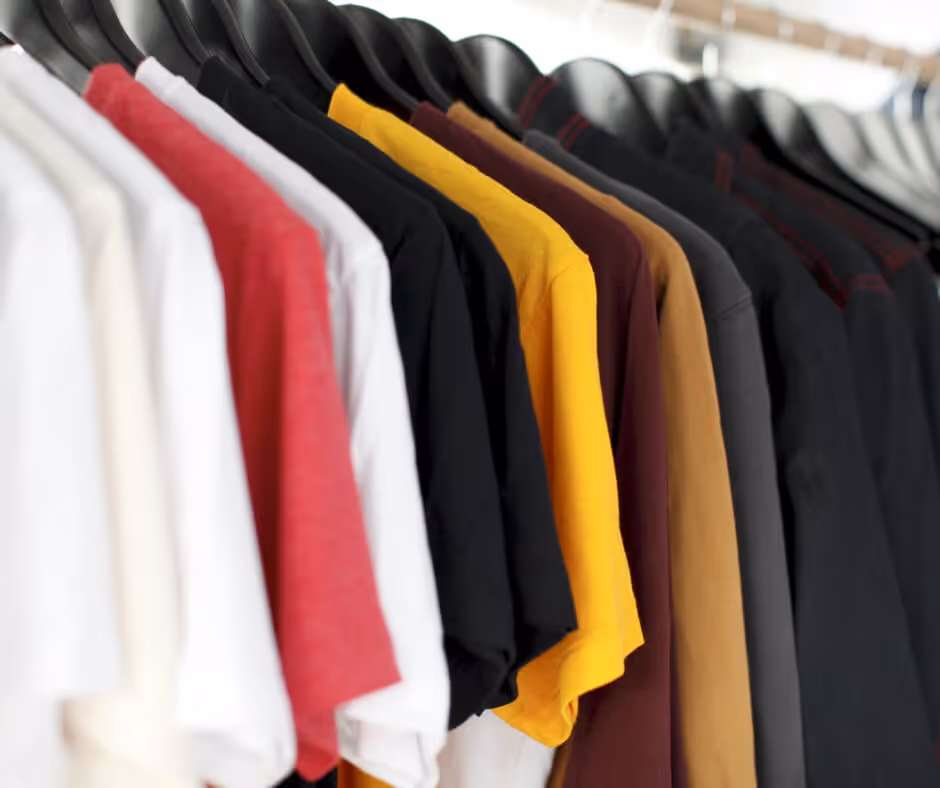 A row of shirts hanging on a rack.