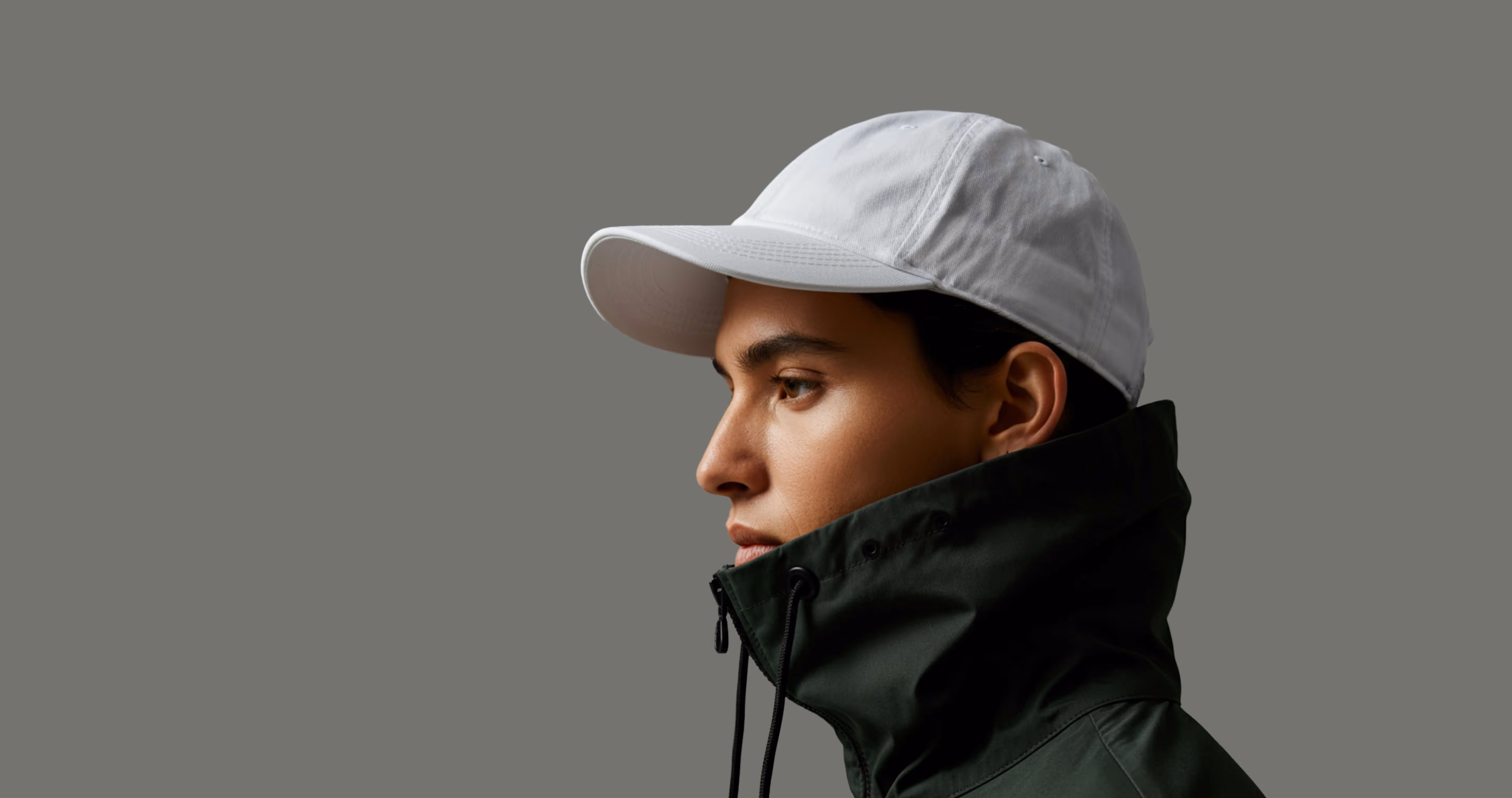 A man wearing a white hat and green jacket.