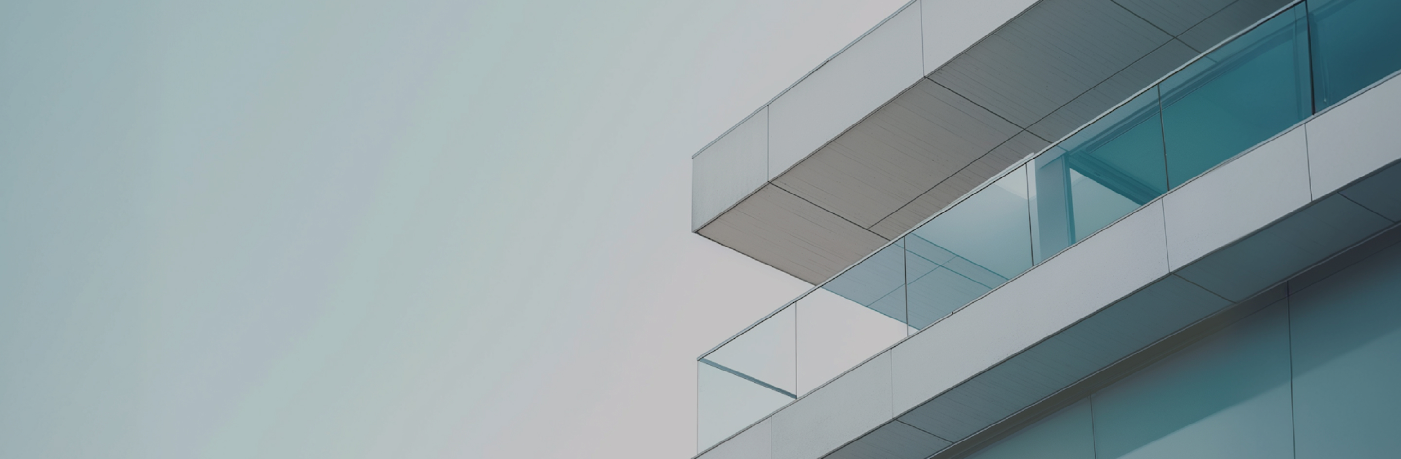 A tall building with balconies against a blue sky.