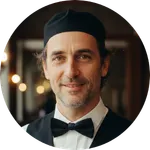 Happy male waiter smiling in a professional restaurant setting