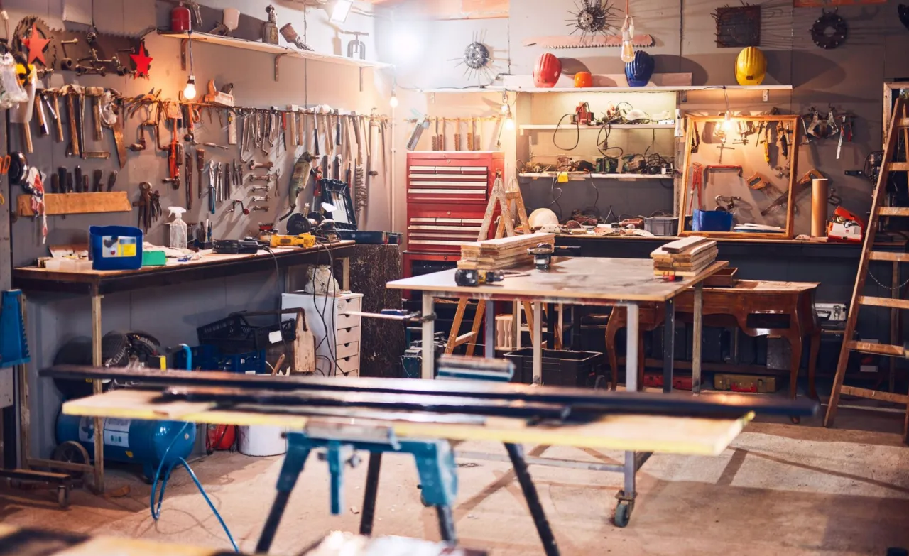 A well-equipped professional woodworking and craft workshop with various hand tools, workbenches, and organized equipment, representing a high-quality manual labor environment.