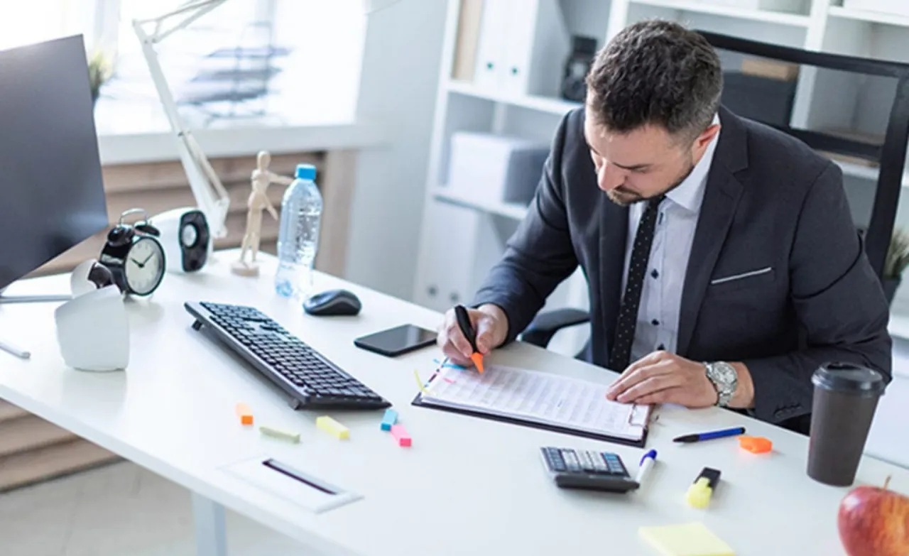 A busy hospital corridor with diverse medical professionals, including doctors in white coats and nurses in blue scrubs, walking and discussing patient care.
